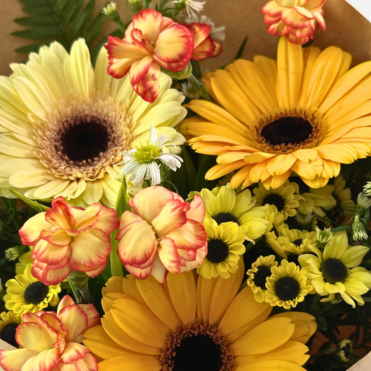 Mentari Bouquet from Century Flower Bunga Kita Collection with yellow gerberas and orange carnations in a rustic kraft wrap.