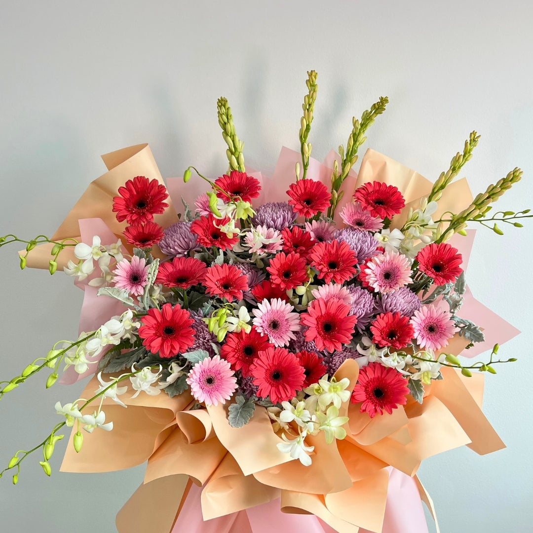 opening flower stand of red, pink, and white flowers with greenery on a light gray background