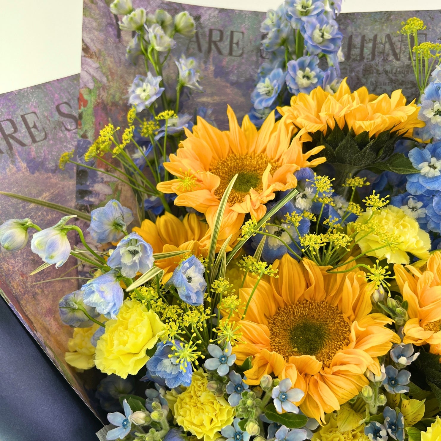 Bouquet of sunflowers and blue flowers with a blurred background