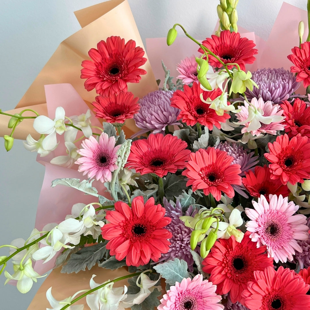 flower opening stand of colorful flowers including red, pink, and purple gerberas on a light gray background.