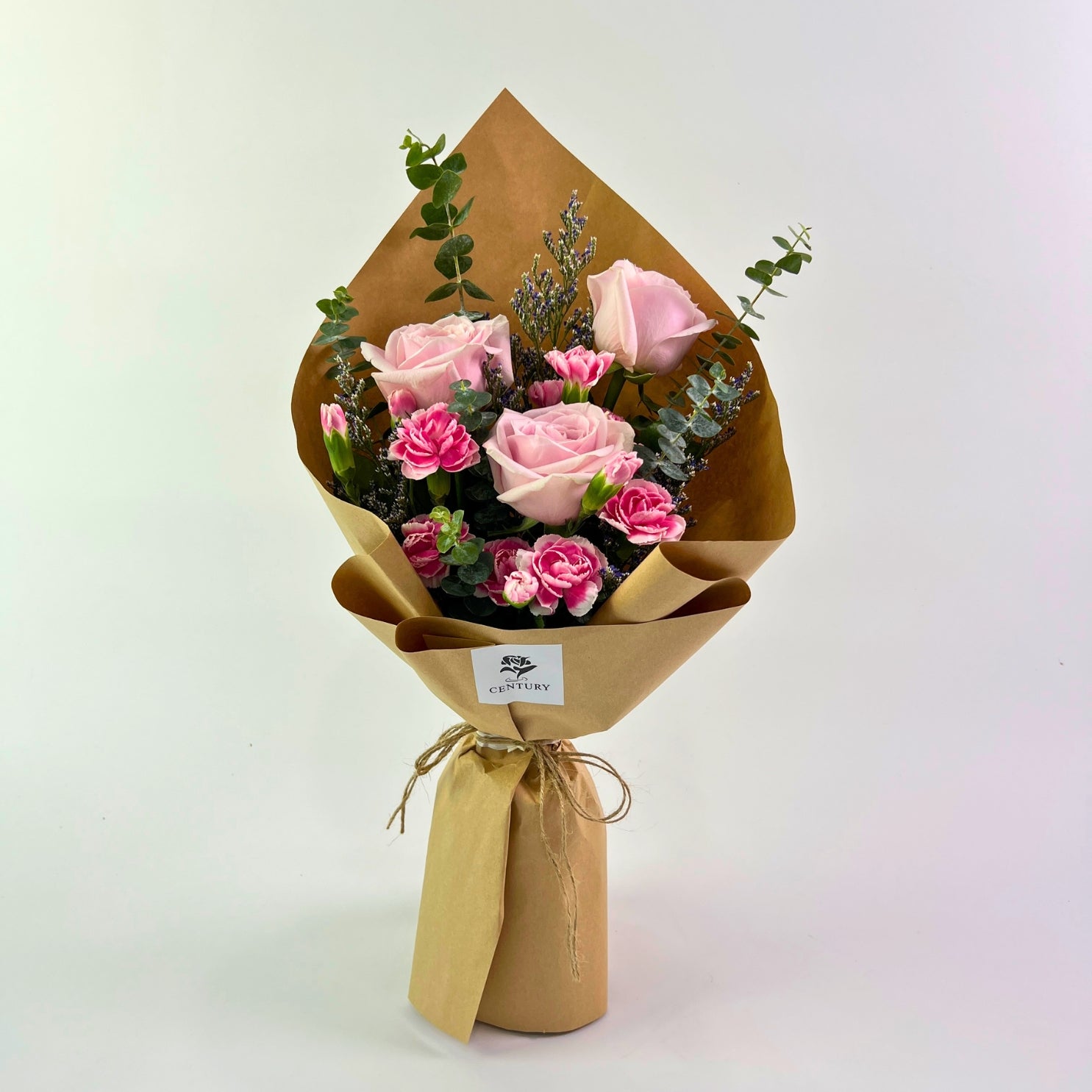 Asmara Bouquet from Century Flower Bunga Kita Collection with pink roses, carnations, and eucalyptus in a rustic kraft wrap.