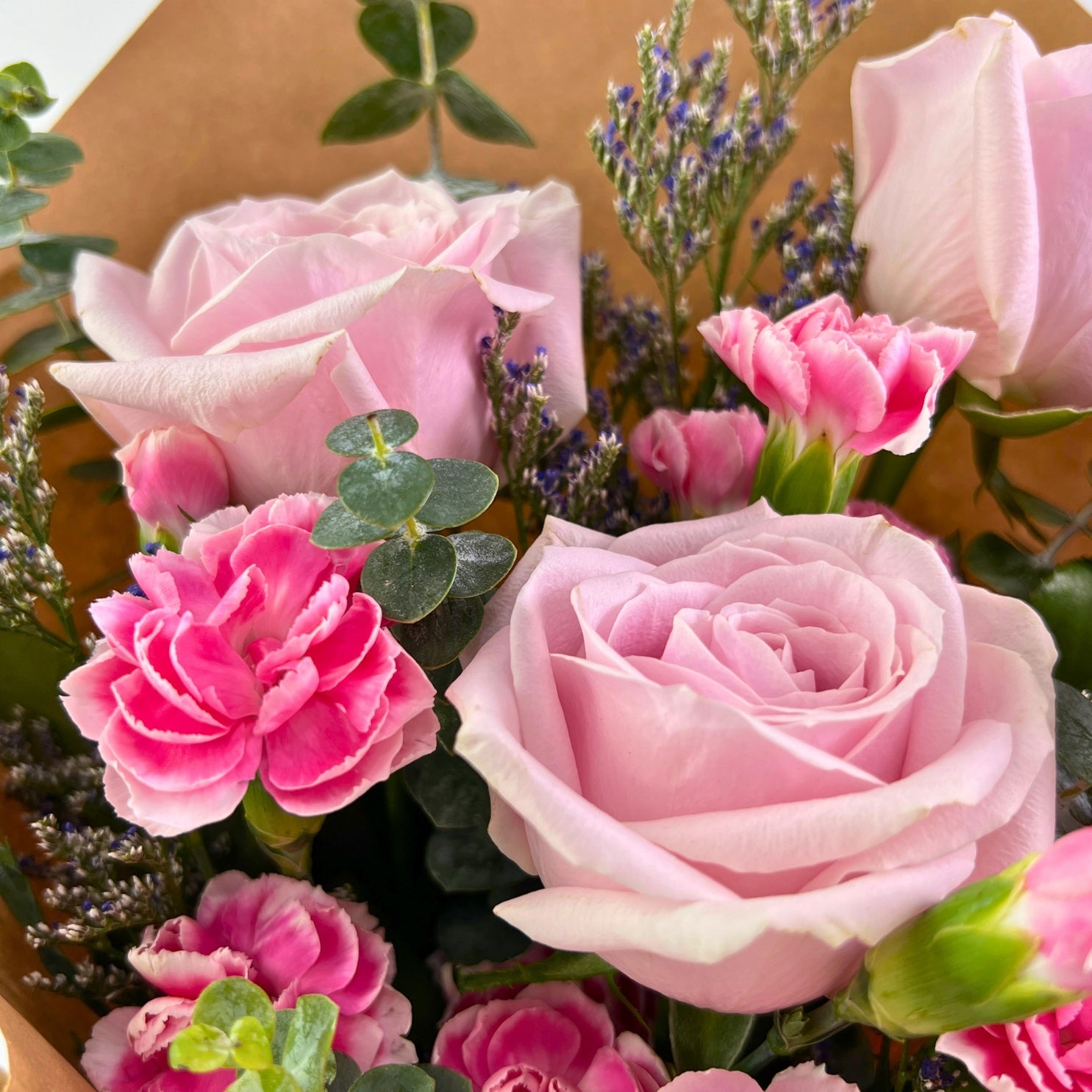 Asmara Bouquet from Century Flower Bunga Kita Collection with pink roses, carnations, and eucalyptus in a rustic kraft wrap.