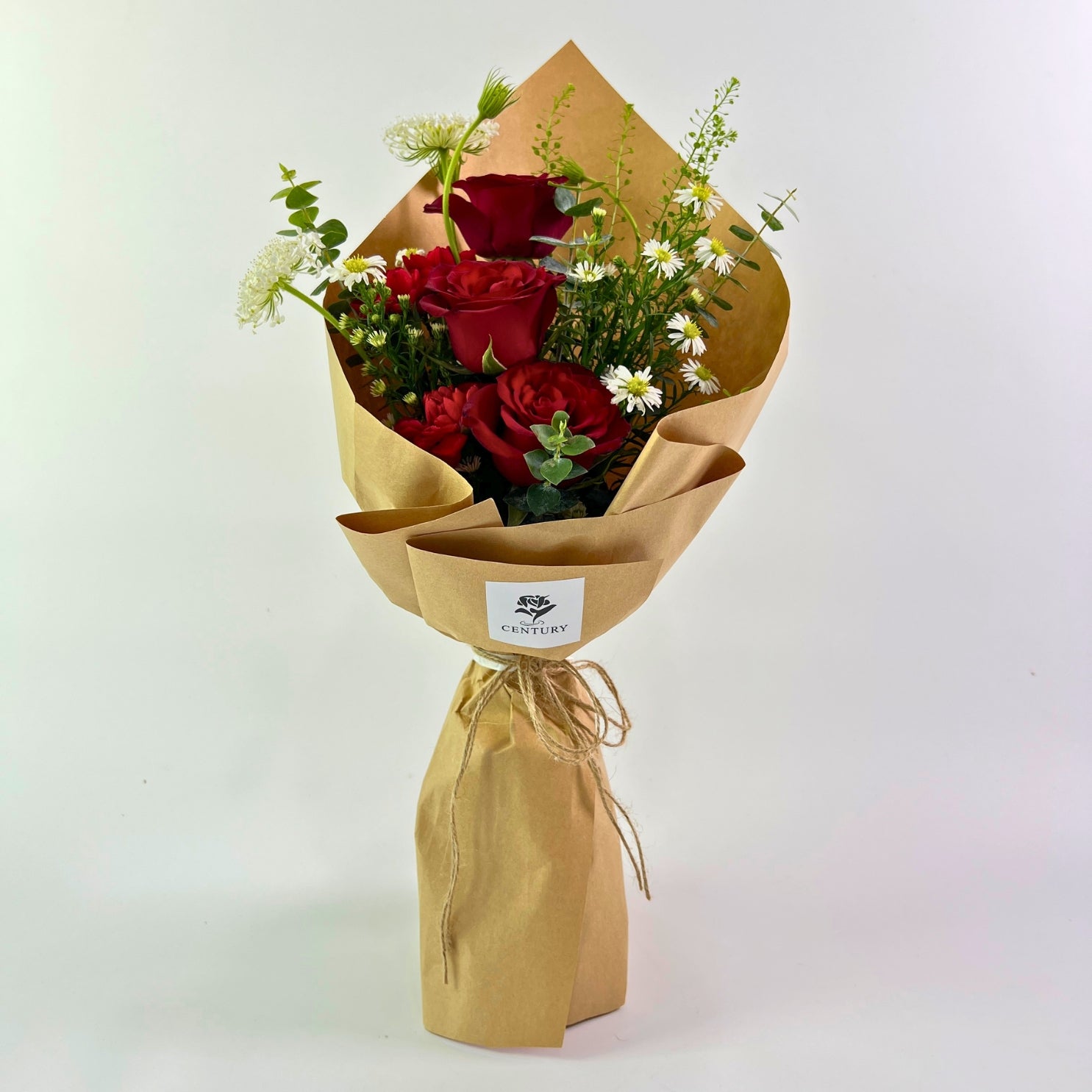 Kasih Bouquet from Century Flower Bunga Kita Collection with red roses and wild chamomile in a rustic kraft wrap.