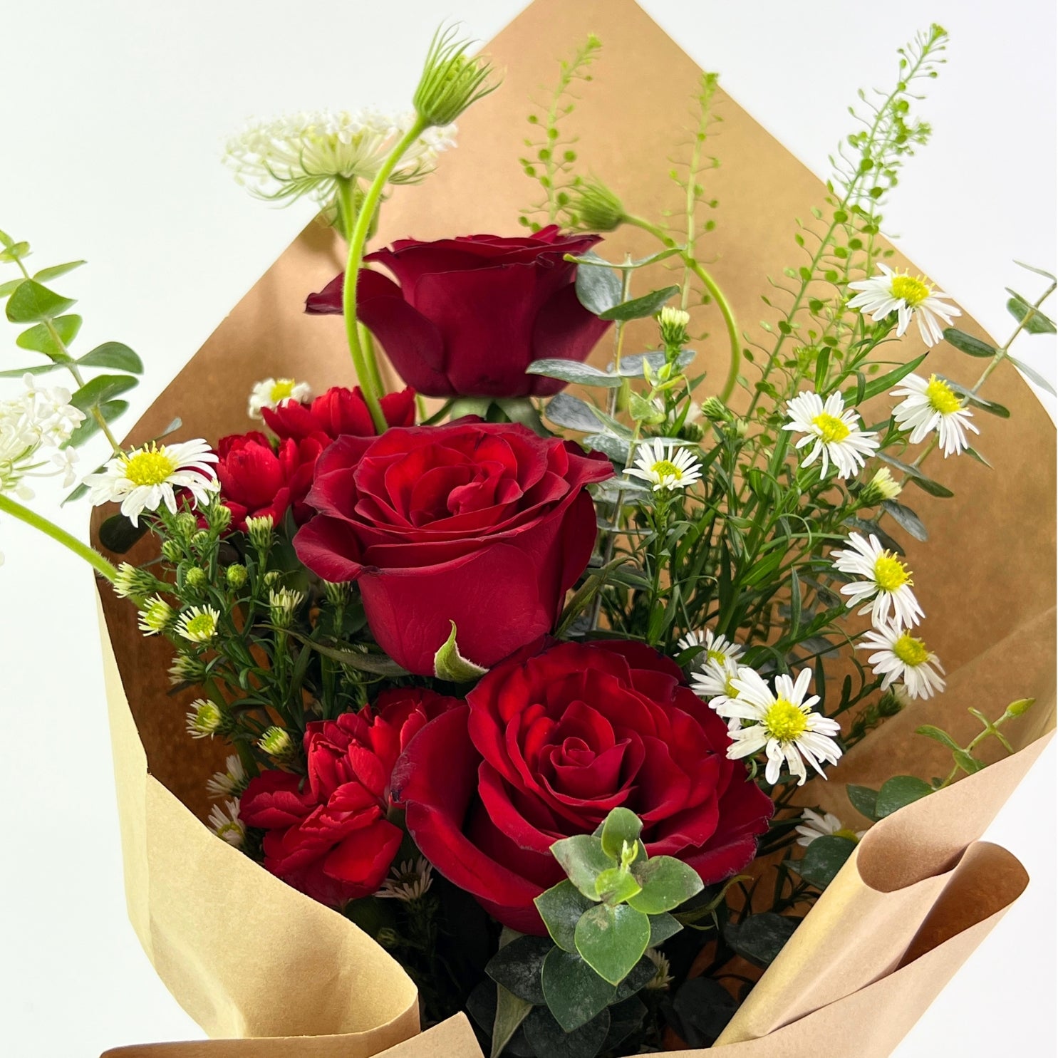 Kasih Bouquet from Century Flower Bunga Kita Collection with red roses and wild chamomile in a rustic kraft wrap.