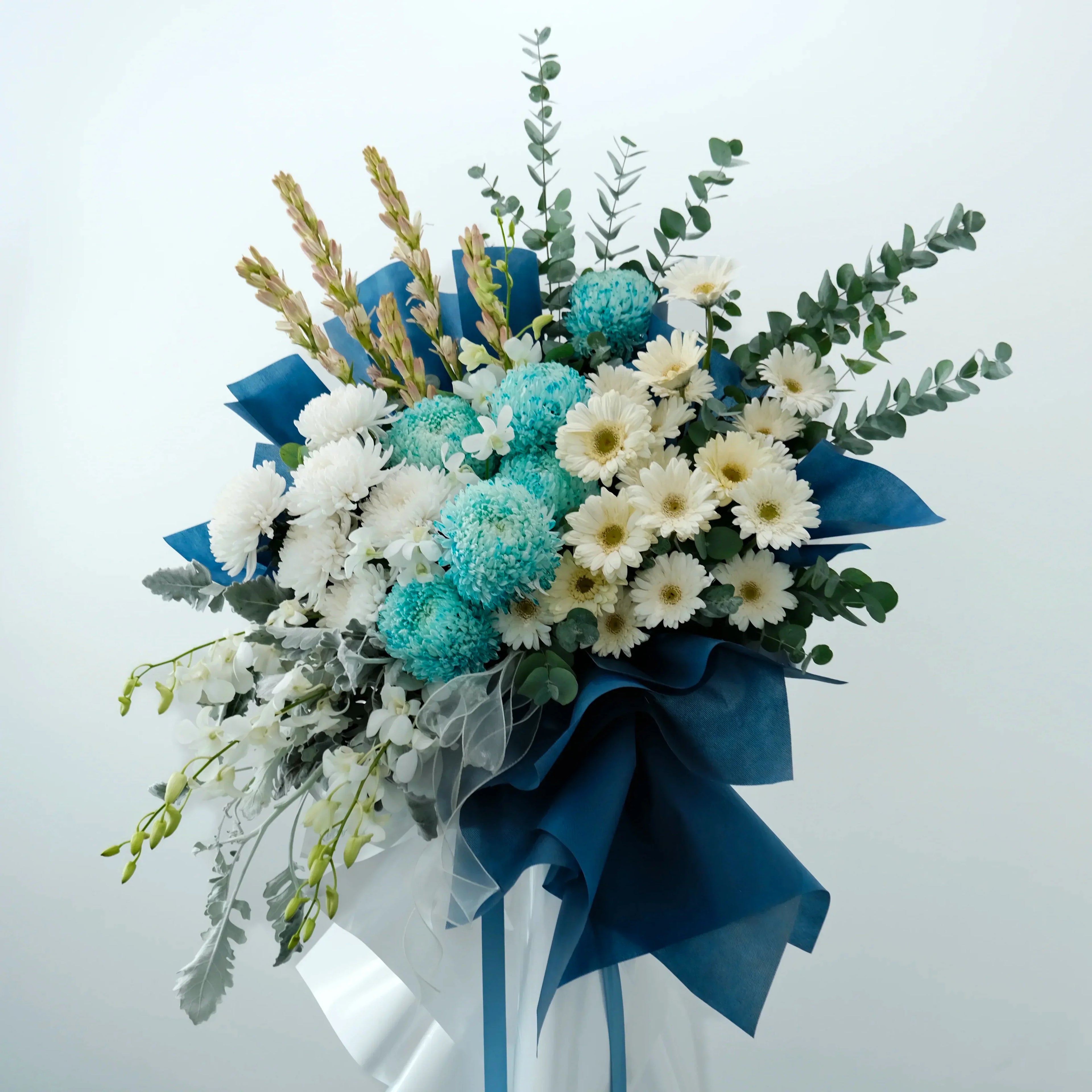 Bouquet of flowers with blue and white ribbons on a light gray background