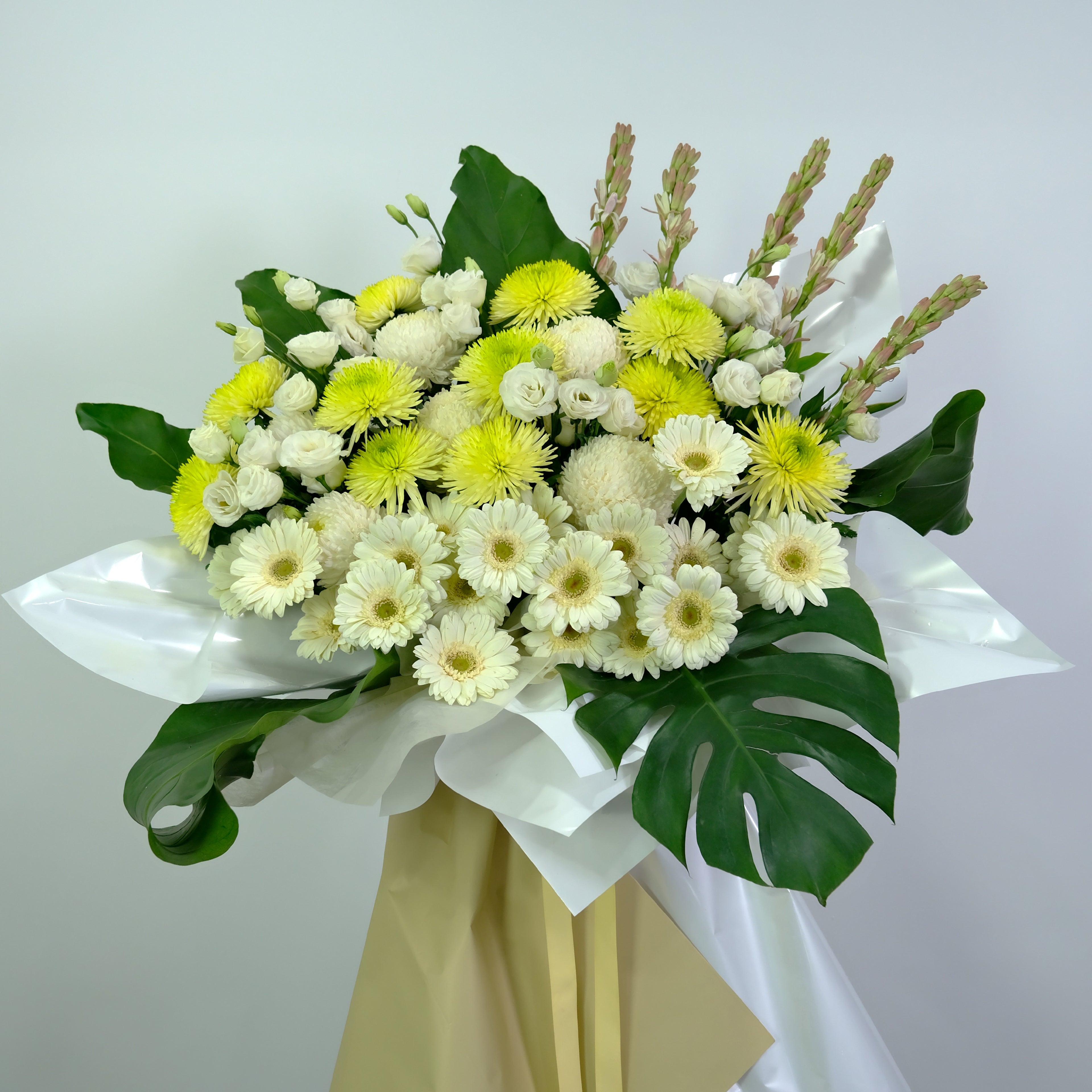 Condolence flower stand with green leaves on a light gray background
