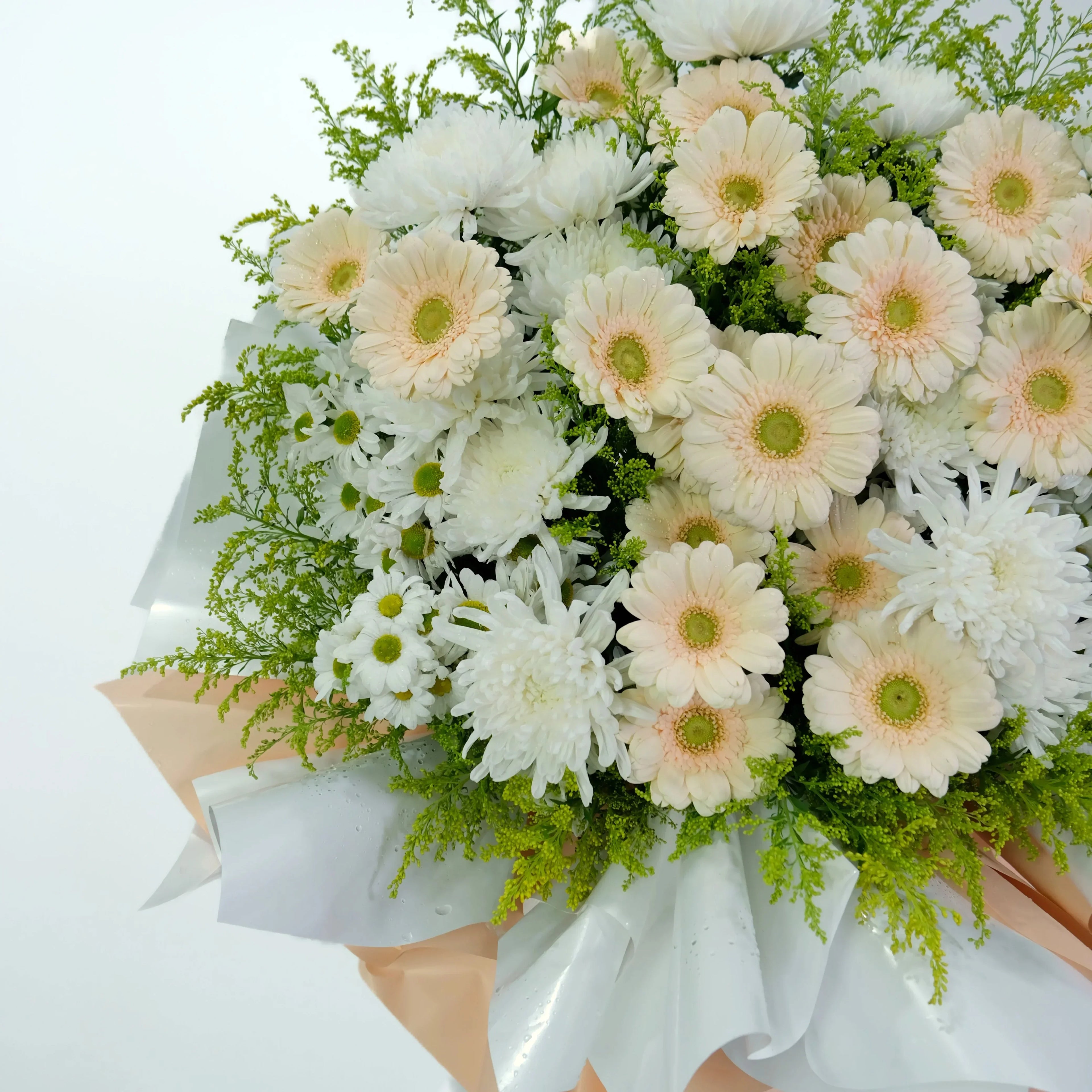 Bouquet of white and peach-colored flowers with greenery on a light background