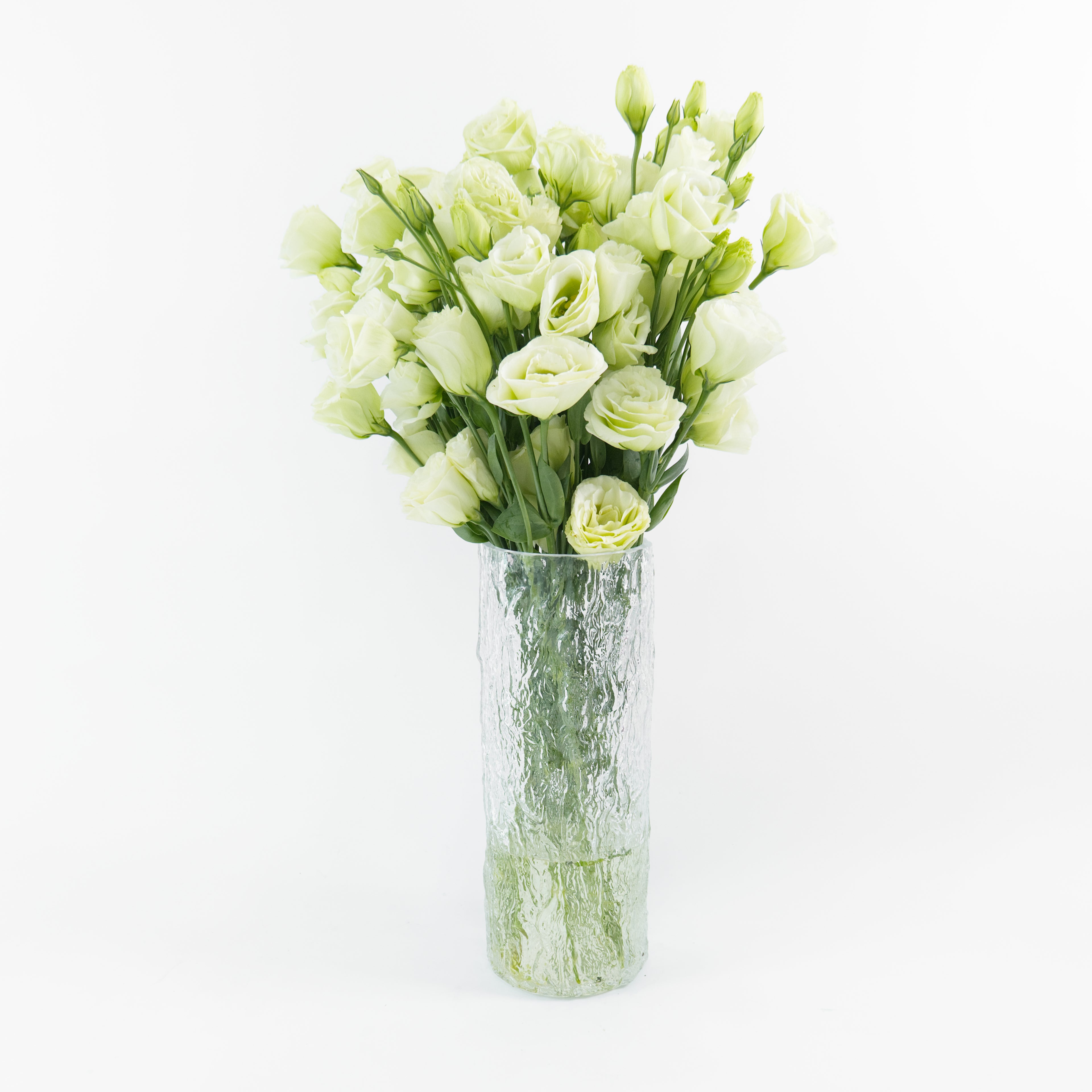 Bundles of wholesale green Lisianthus flowers standing in clean water containers inside a floral cold storage facility in Kuala Lumpur.