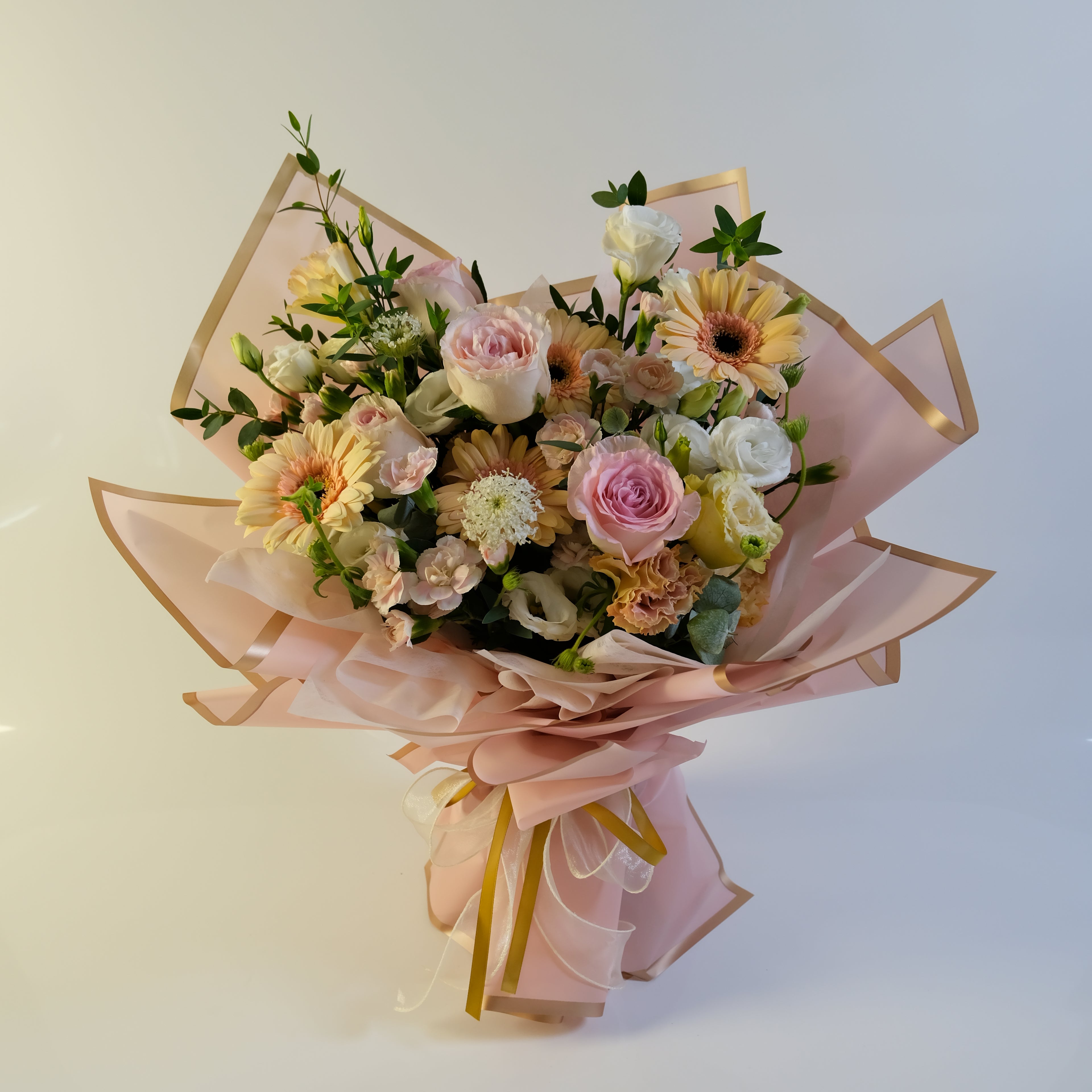 Bouquet of flowers with pink ribbons on a light background