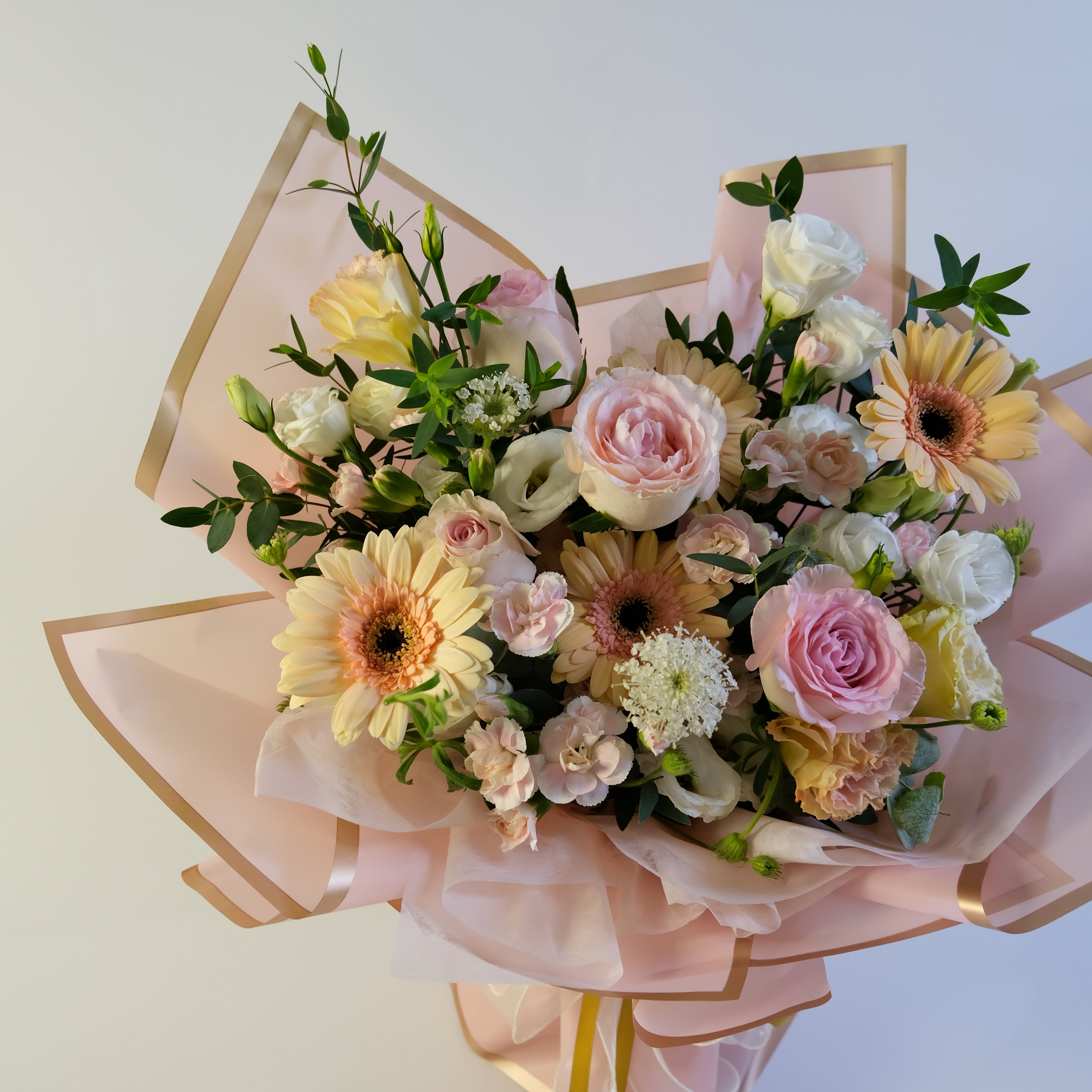 Bouquet of flowers with pink ribbons on a light background