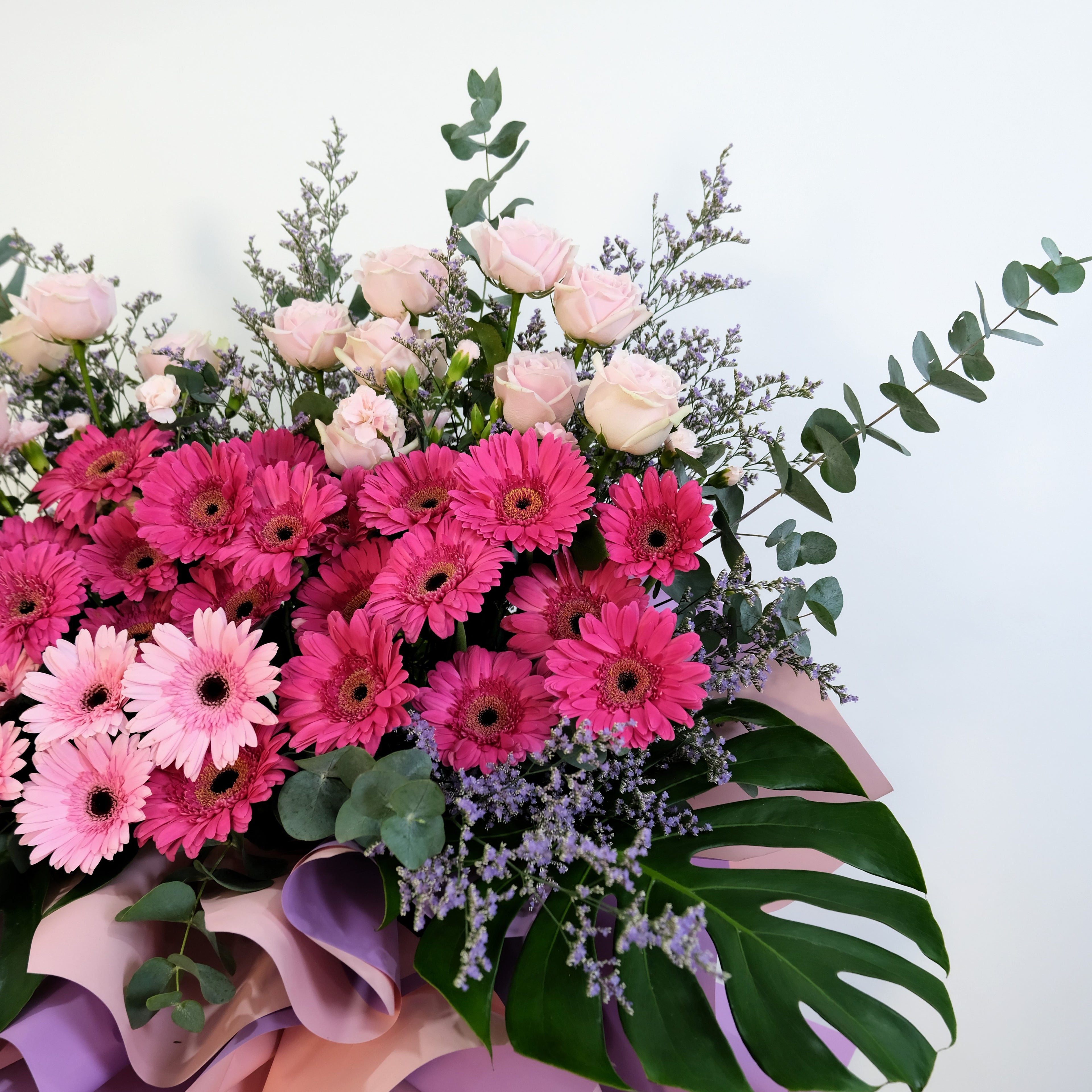 flower stand Bouquet of pink and red flowers with green leaves on a white background