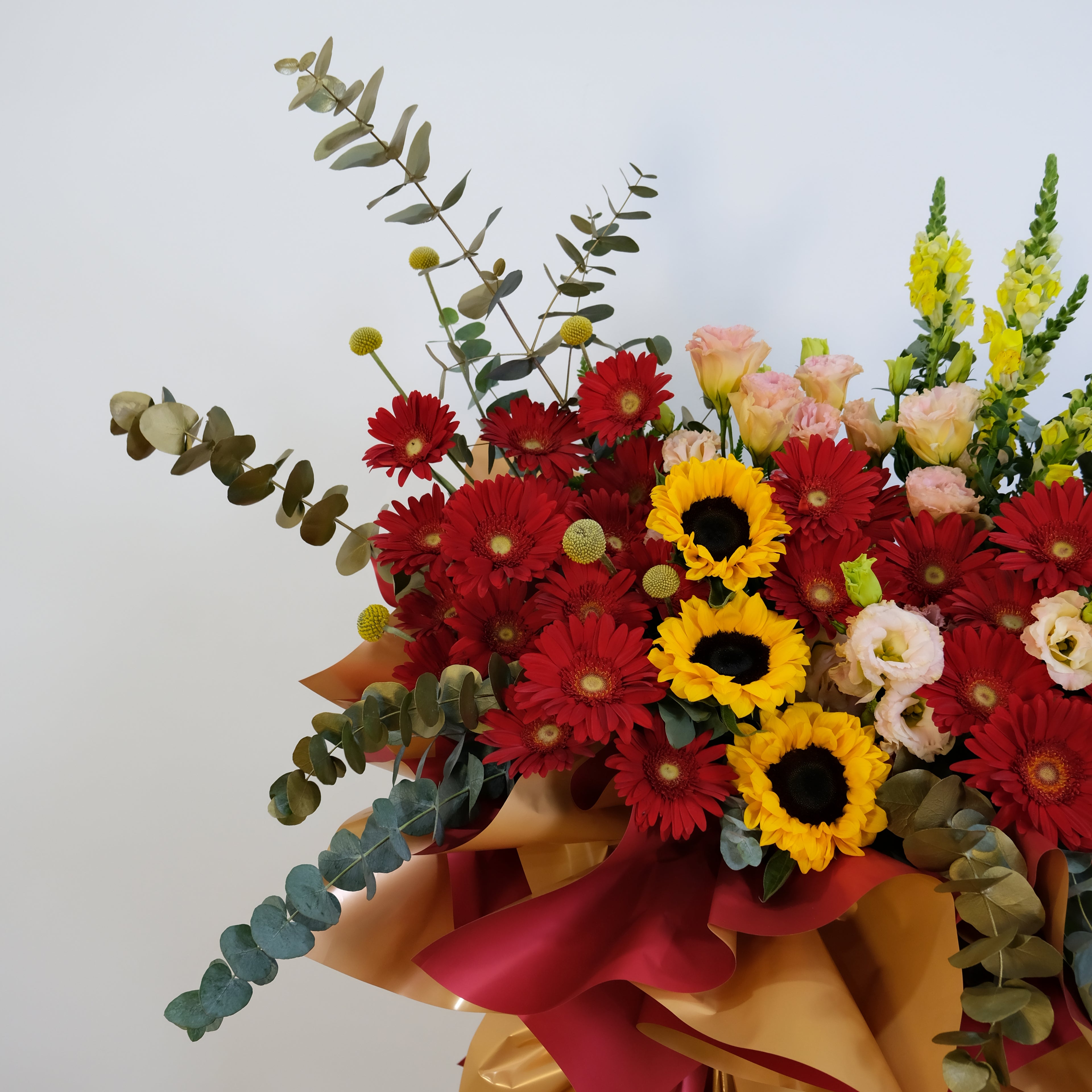 Bouquet of flowers with red, yellow, and pink flowers on a white background