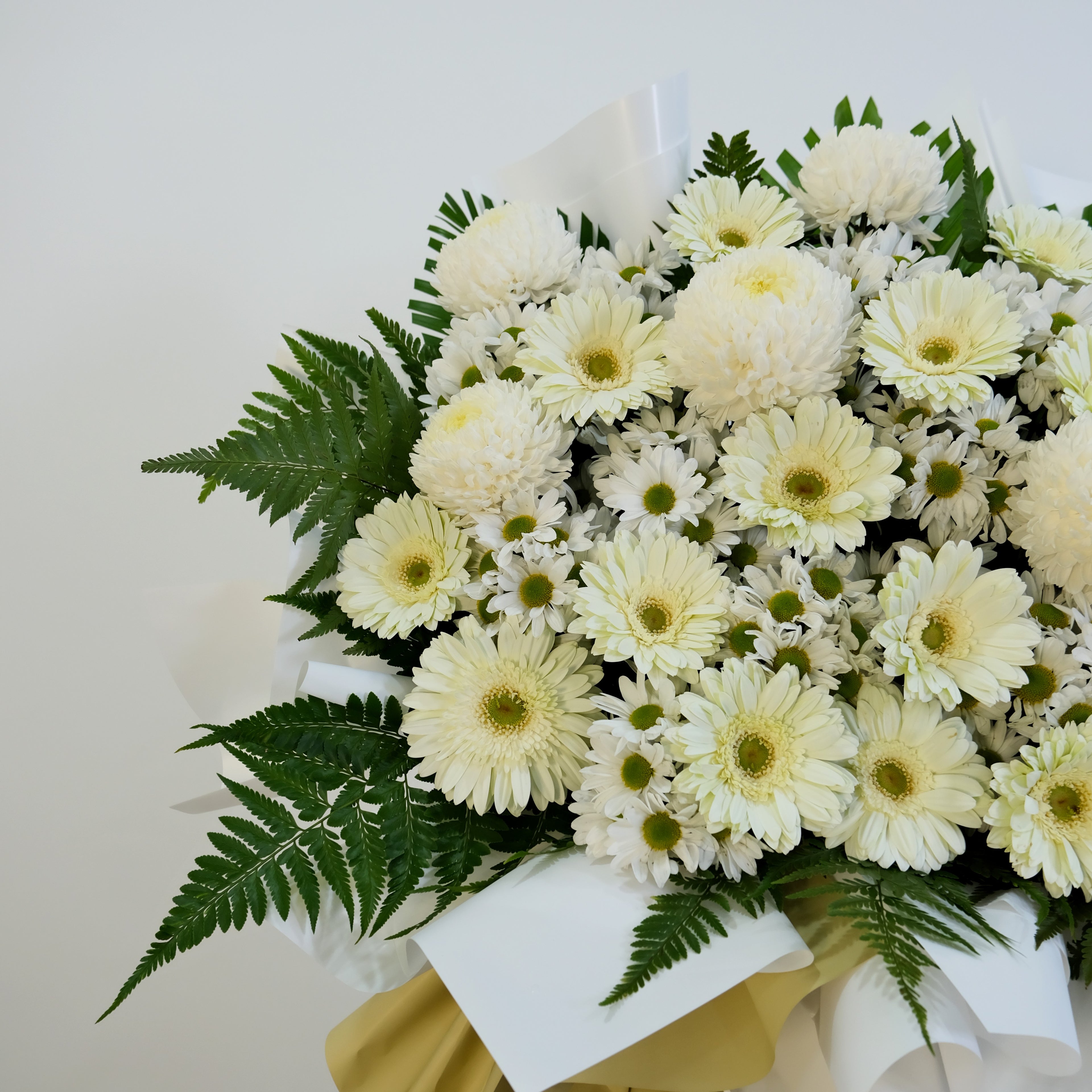 Bouquet of white flowers with green leaves on a light background