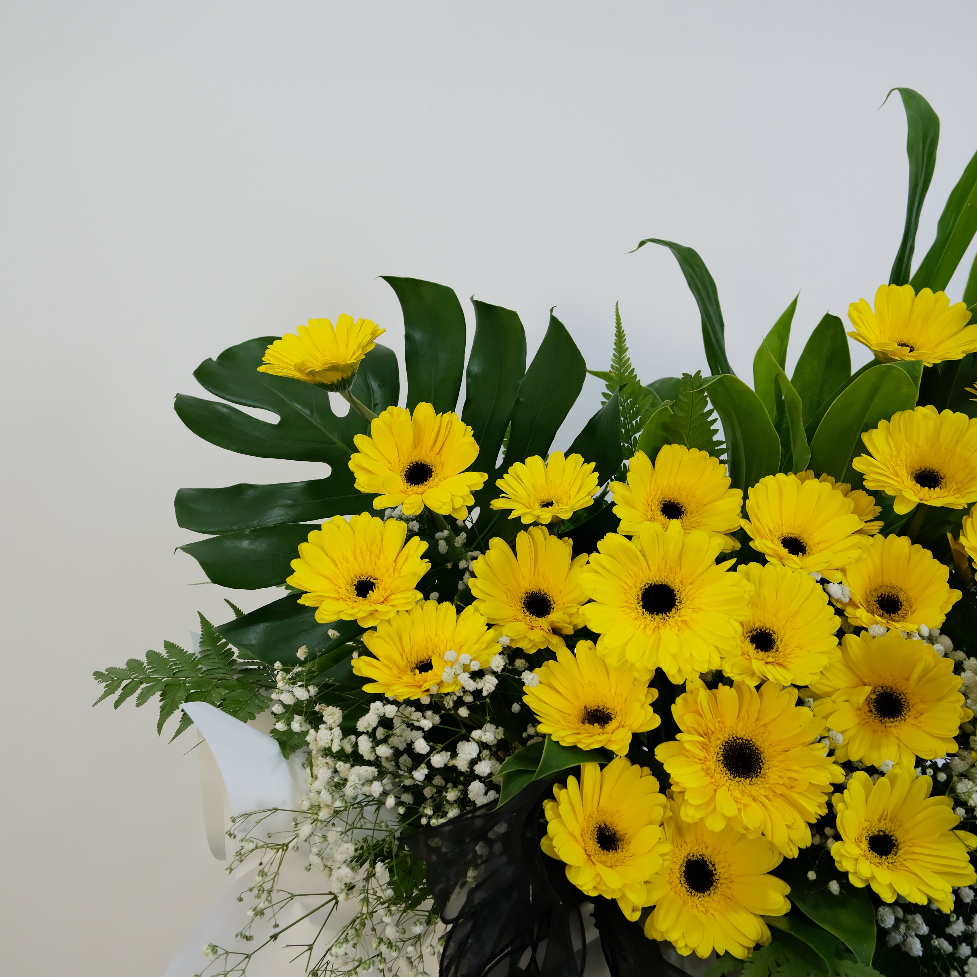 Bouquet of yellow flowers with green leaves on a white background
