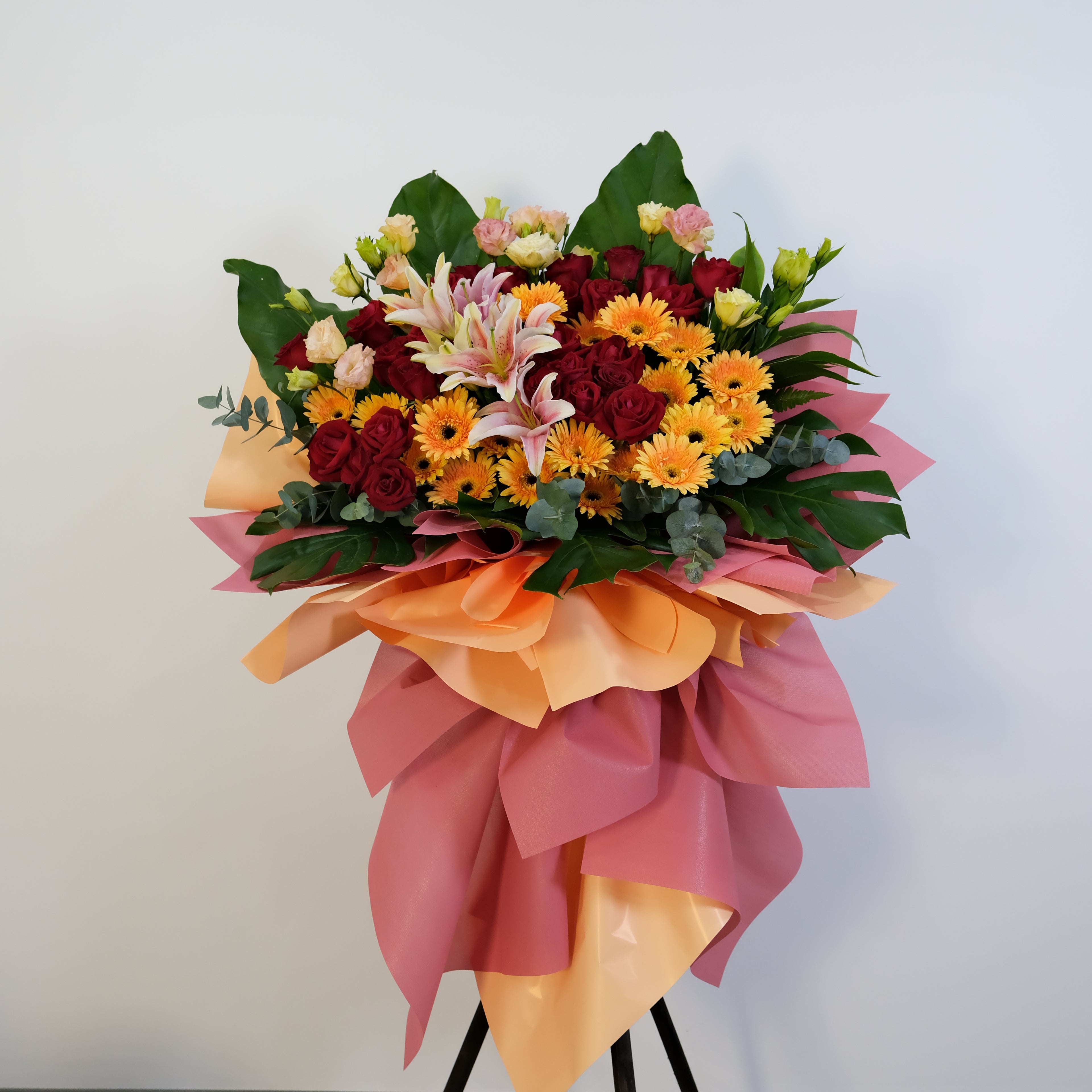 Opening flower stand with lilies, gerbera and roses