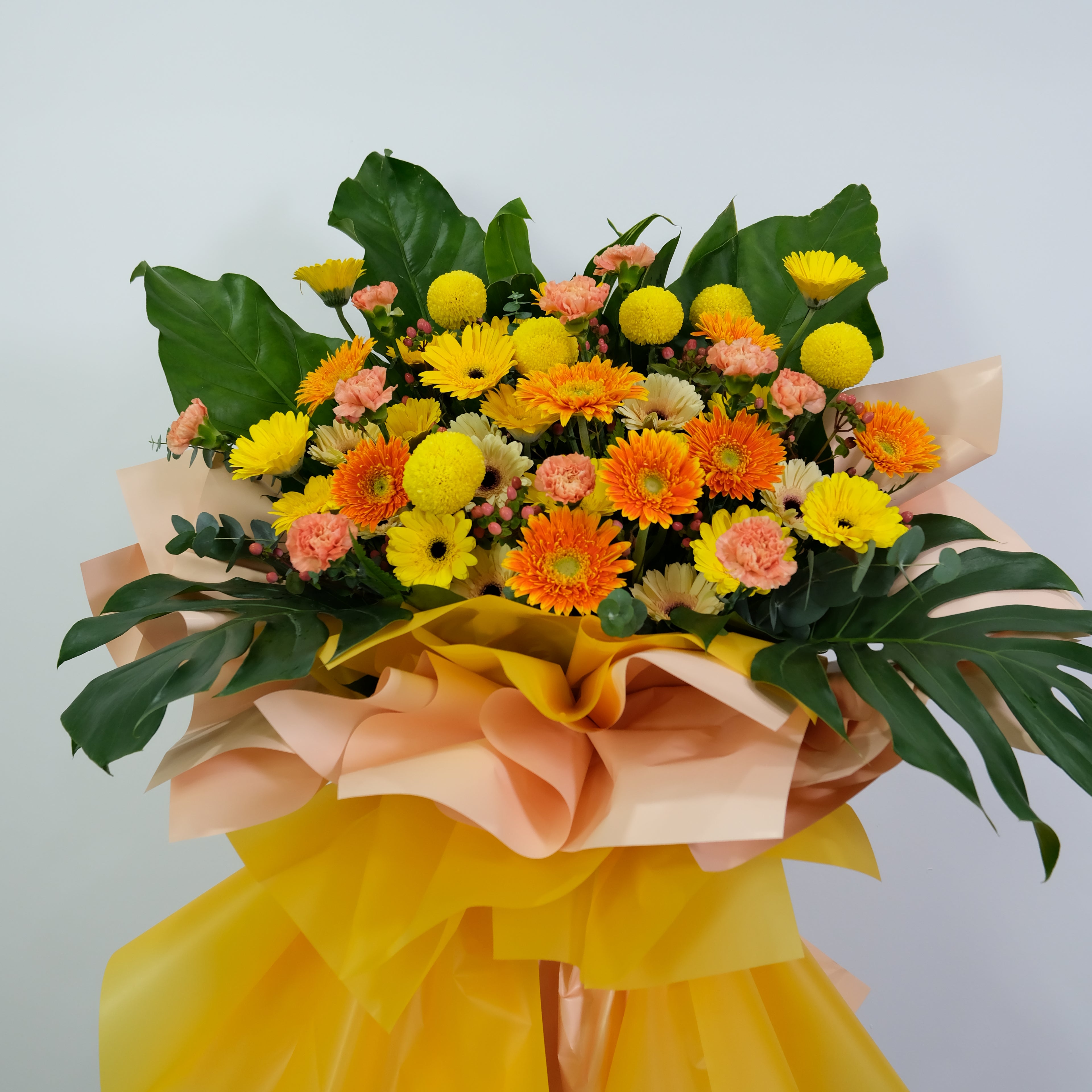 opening flower stand with yellow, orange, and pink colors on a light gray background