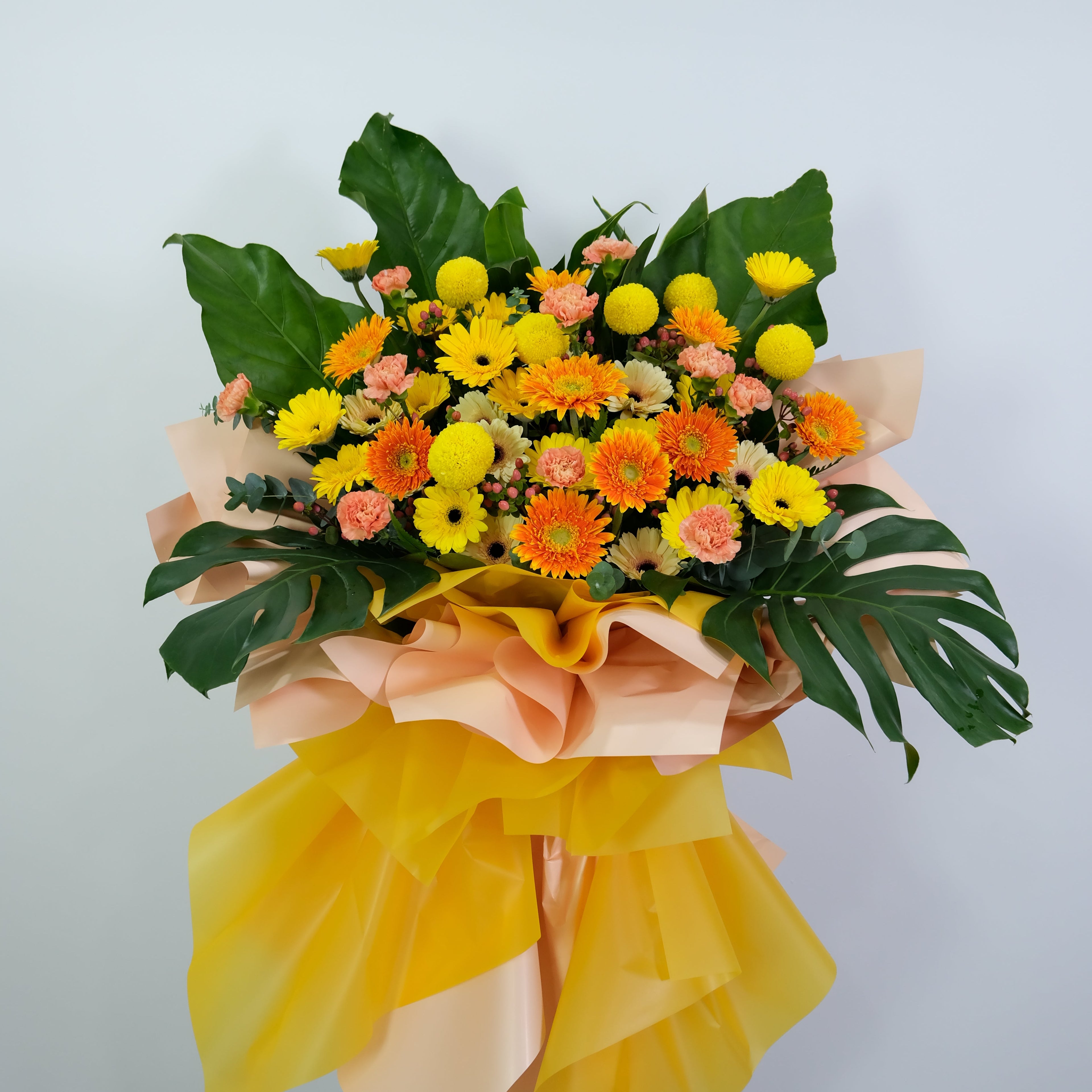 grand opening flower stand with yellow, orange, and pink colors on a light gray background