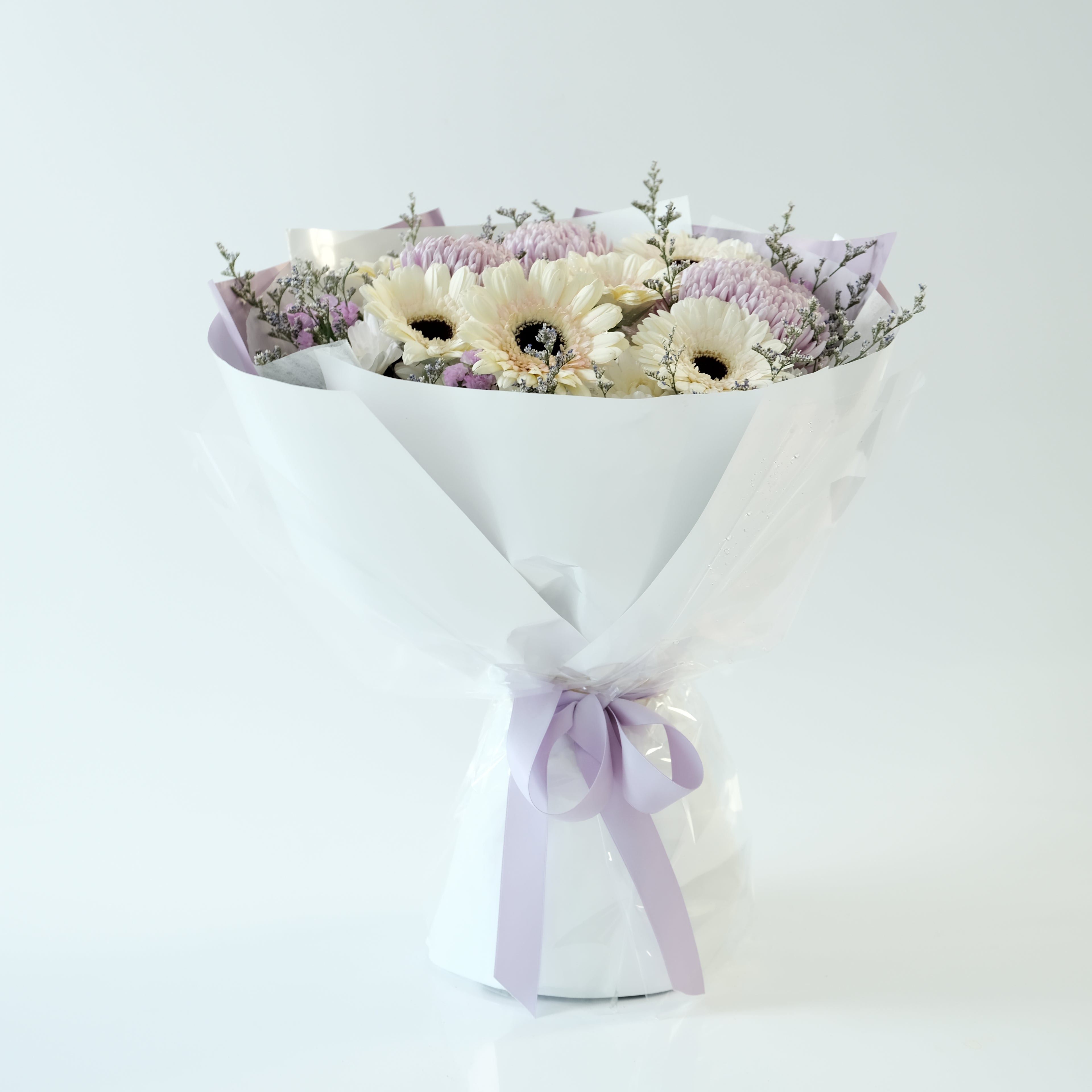 Floral arrangement with a white ribbon on a light gray background