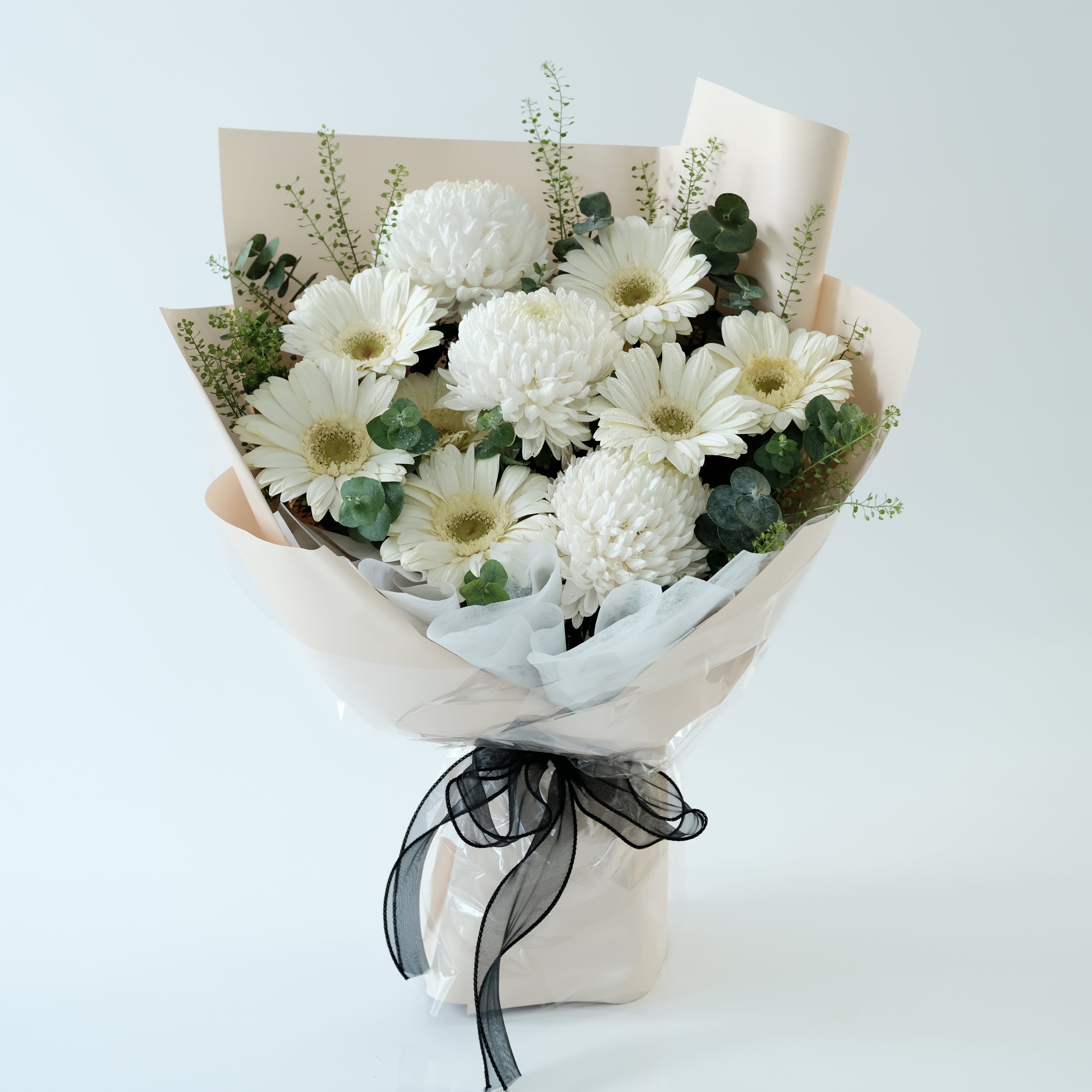 Bouquet of white flowers with greenery and a black ribbon on a light blue background