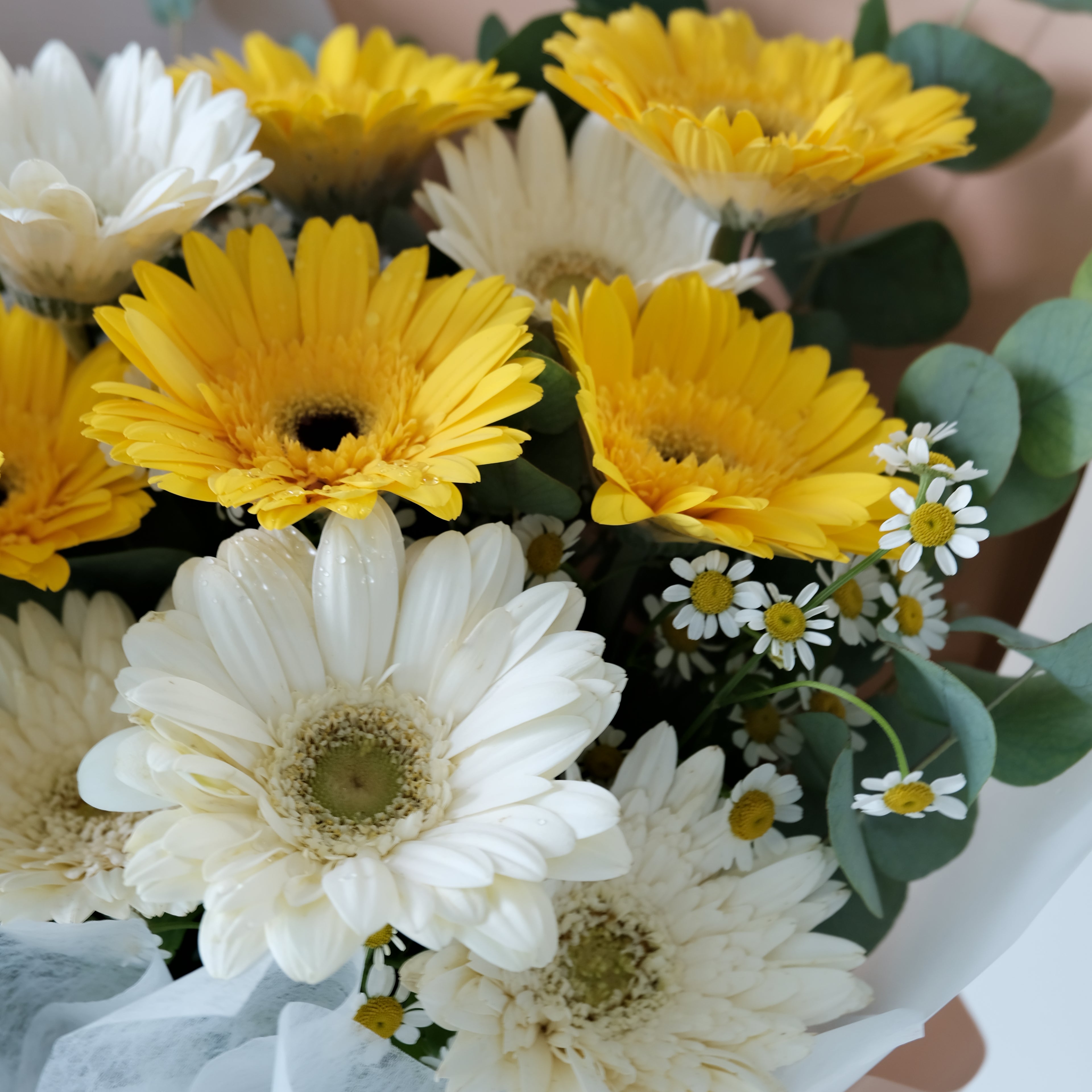 Bouquet of white and yellow flowers with greenery