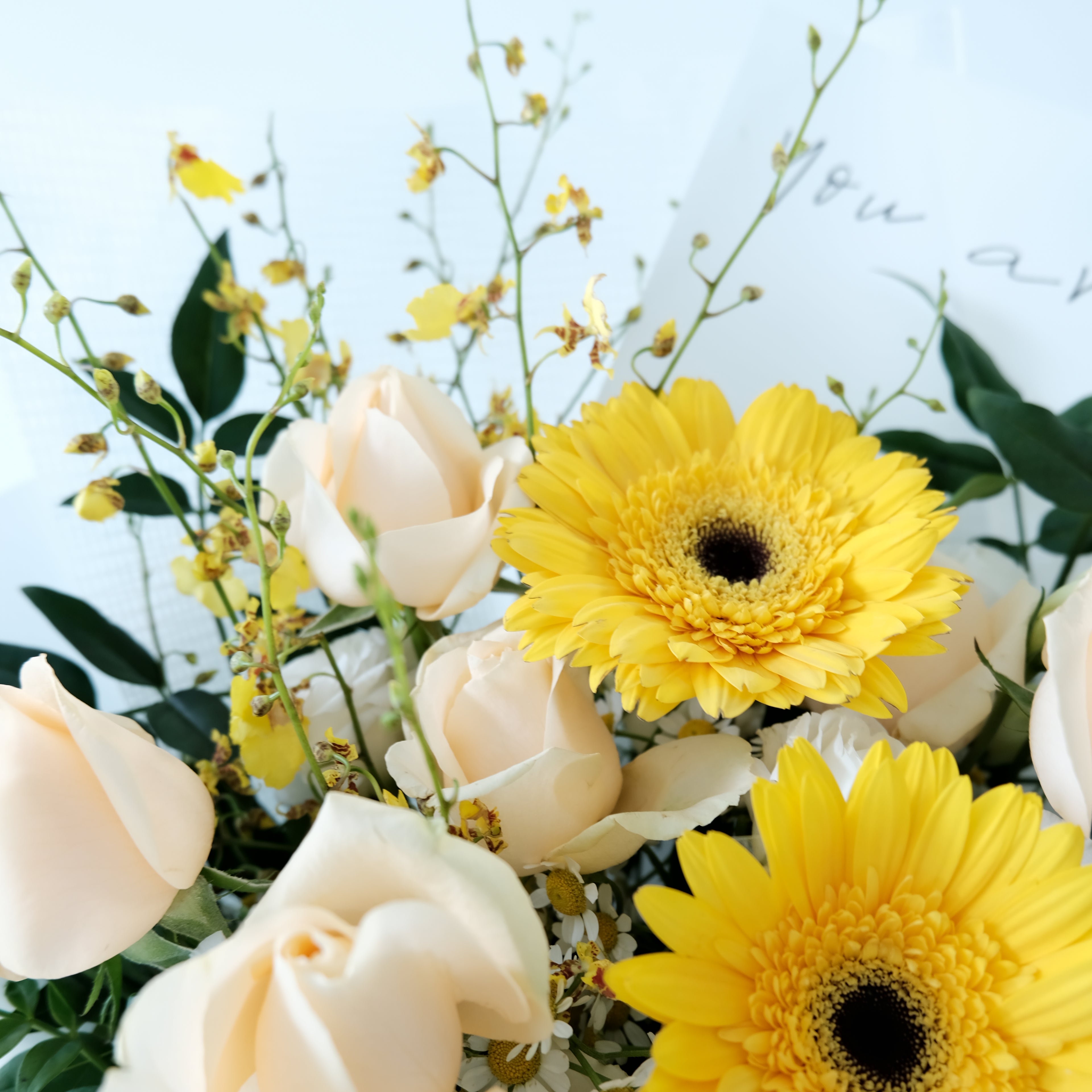 Bouquet of yellow and white flowers with a light blue background