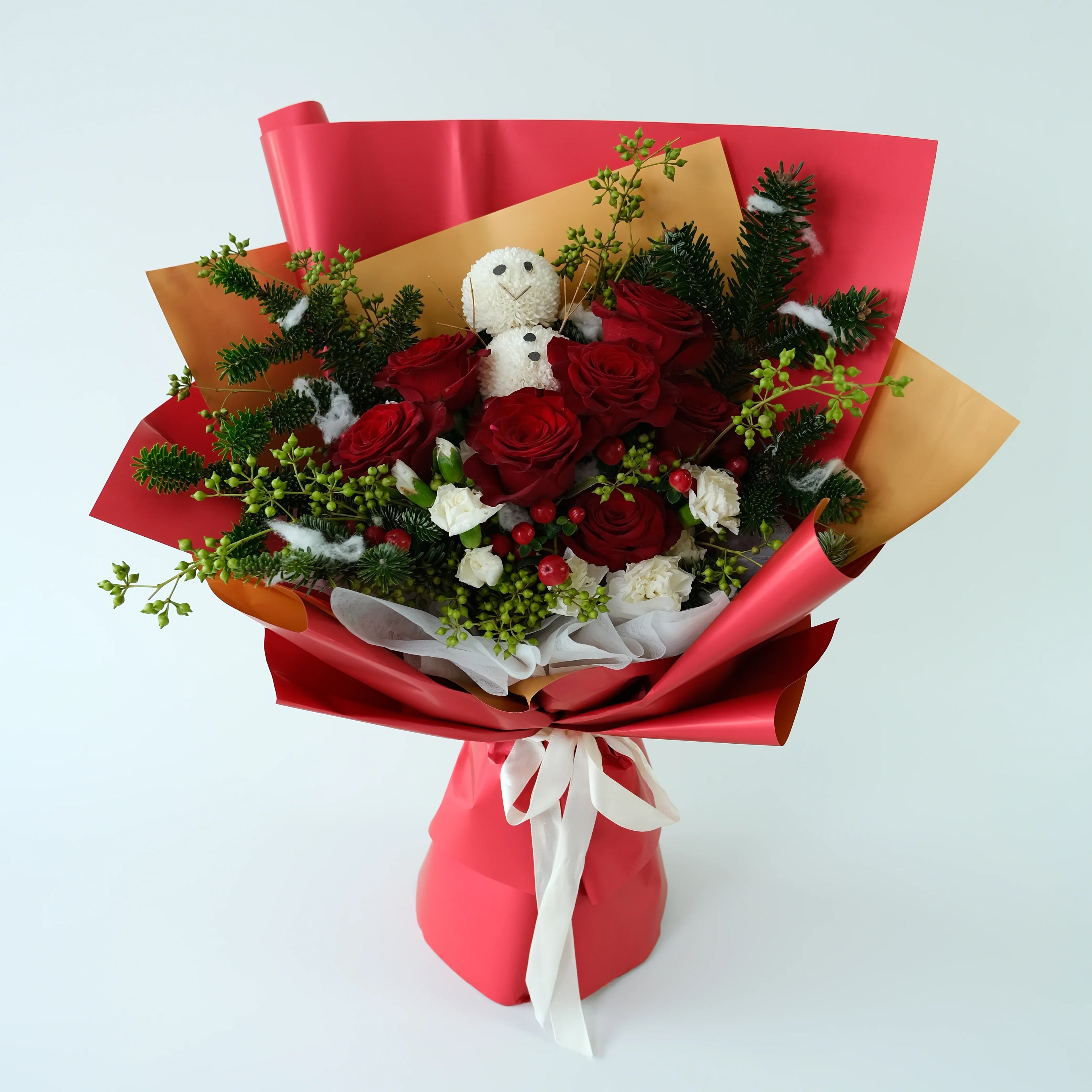 Red rose bouquet with greenery, white flowers, and a snowman ornament in red wrapping