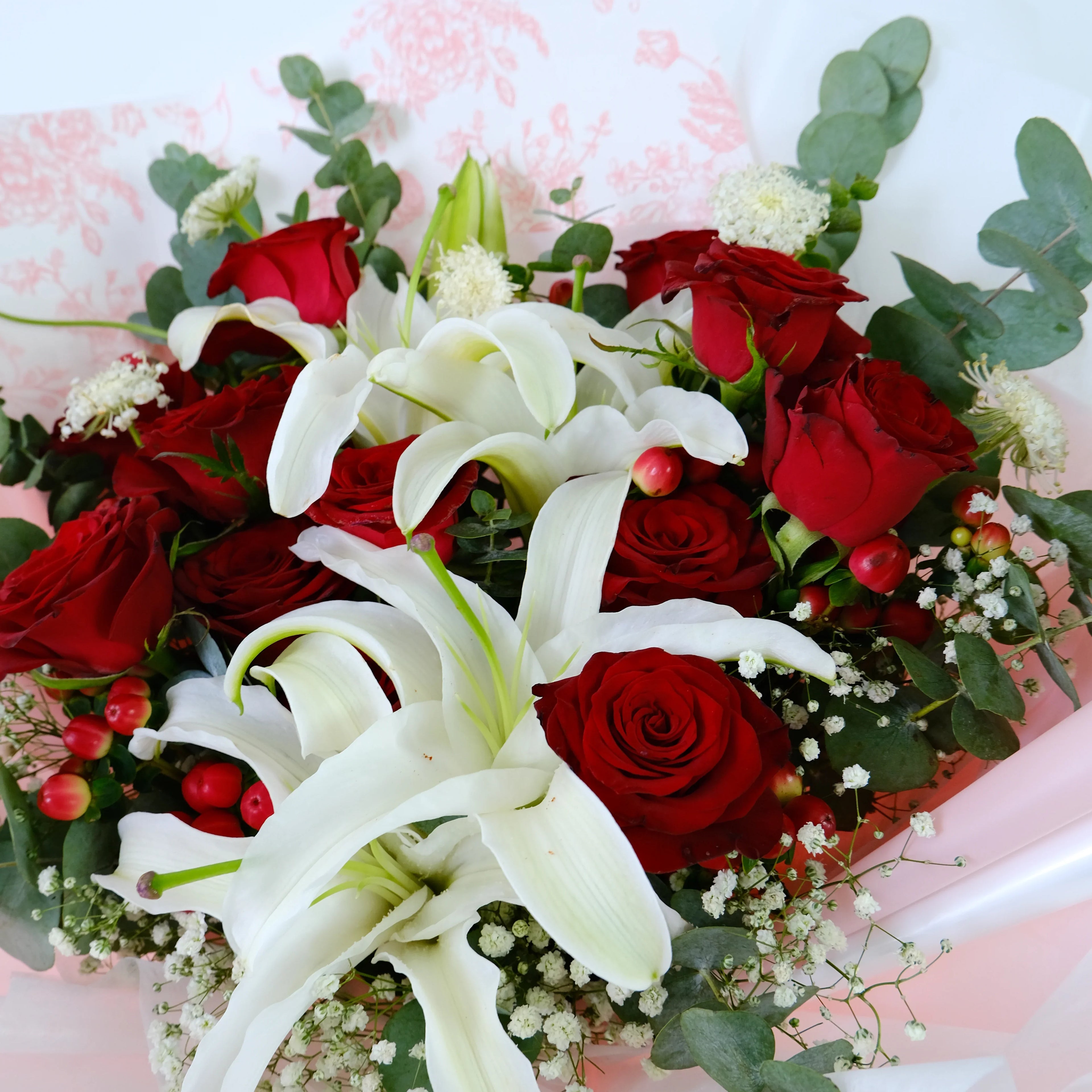 Bouquet of red roses and white lilies with greenery and baby's breath flowers