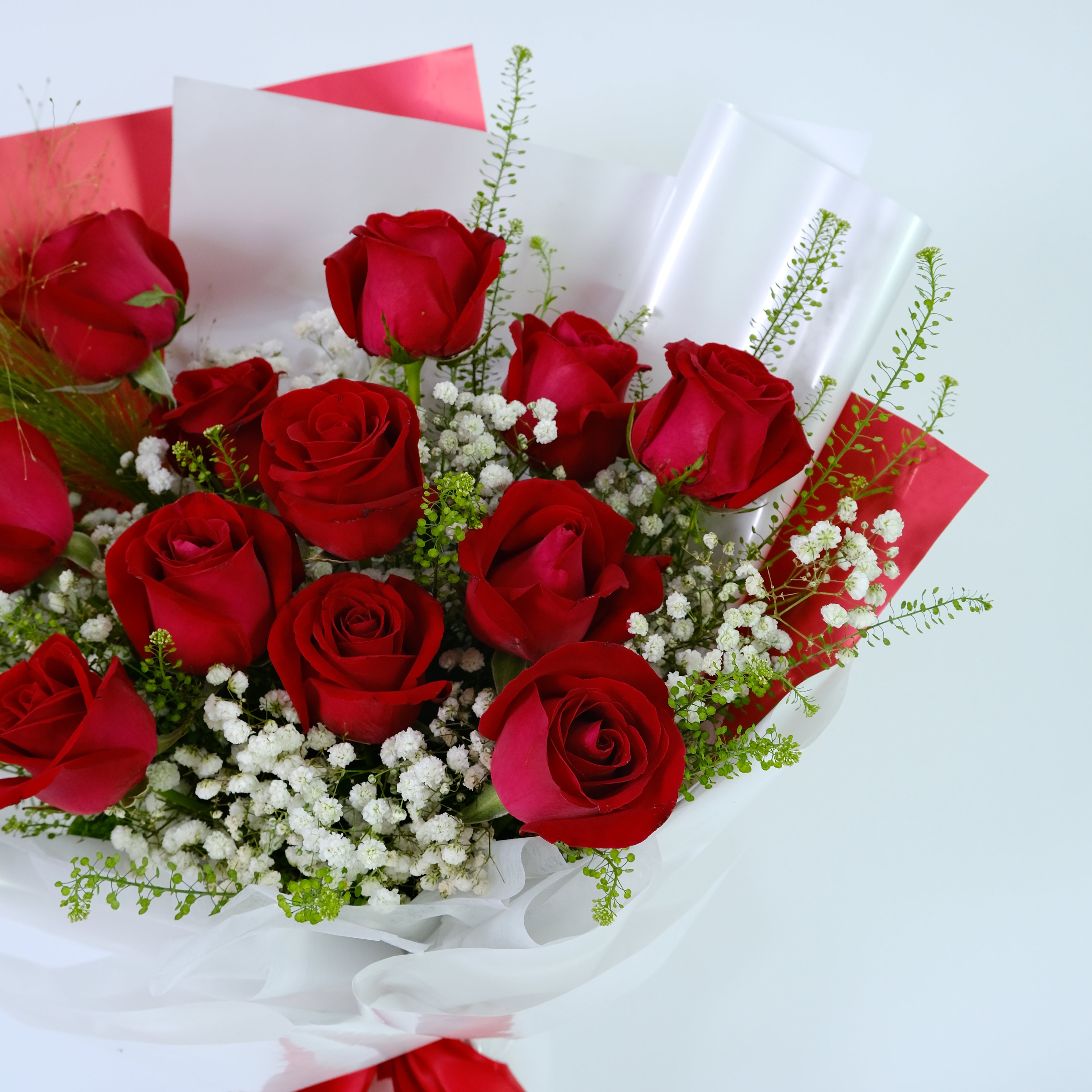 Bouquet of red roses with white baby's breath on a white background