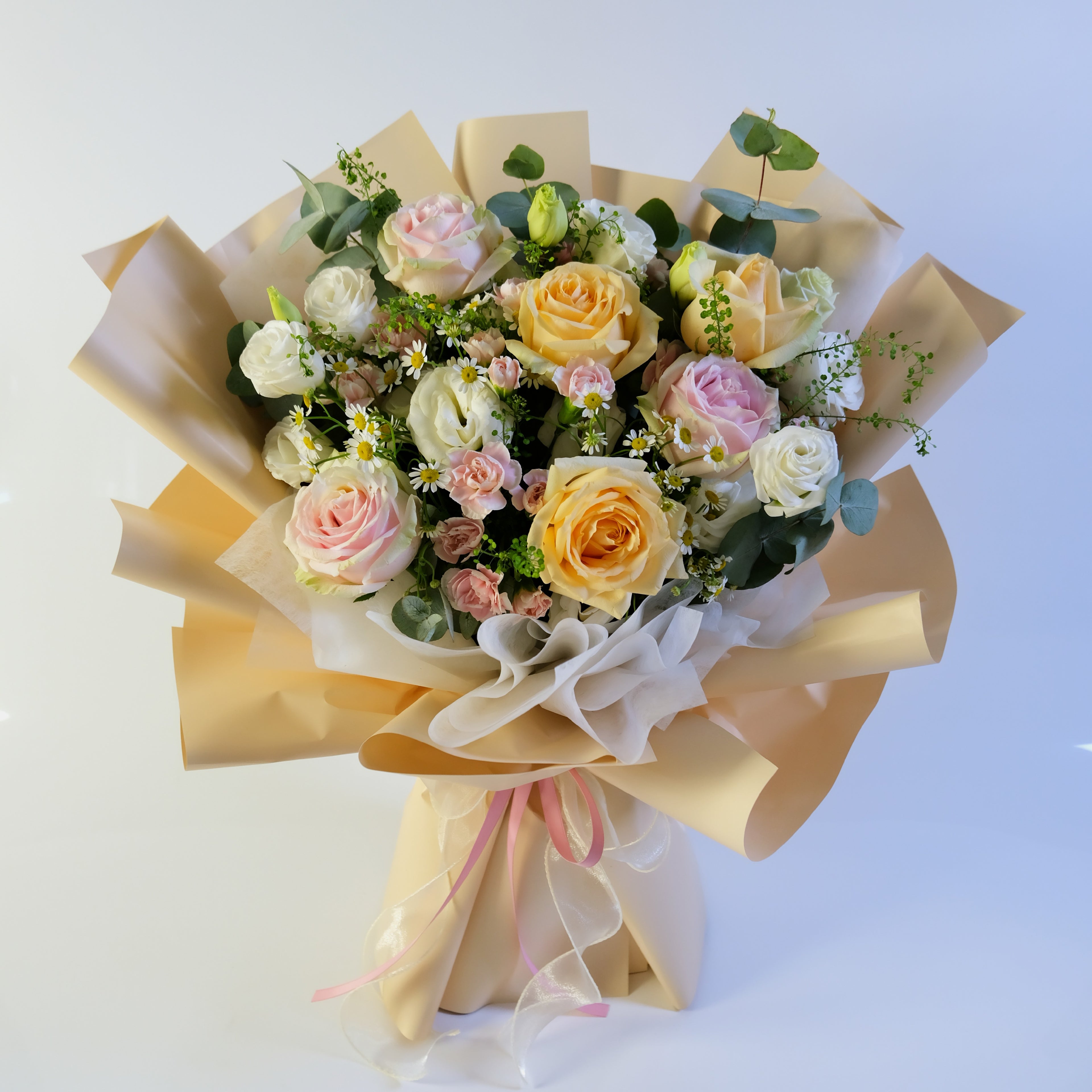 Bouquet of flowers wrapped in beige paper on a light blue background