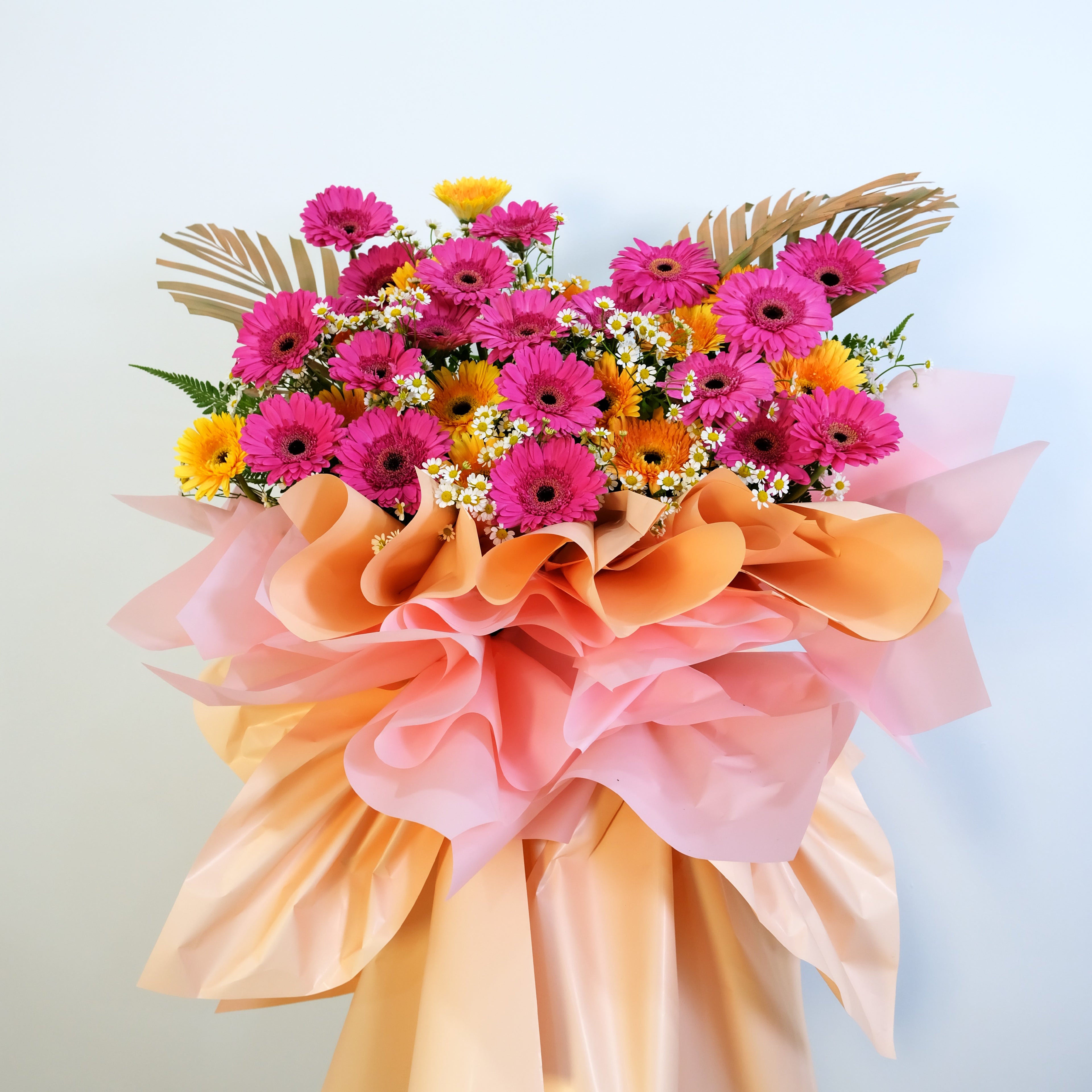Bouquet of flowers with pink, orange, and yellow colors on a light background