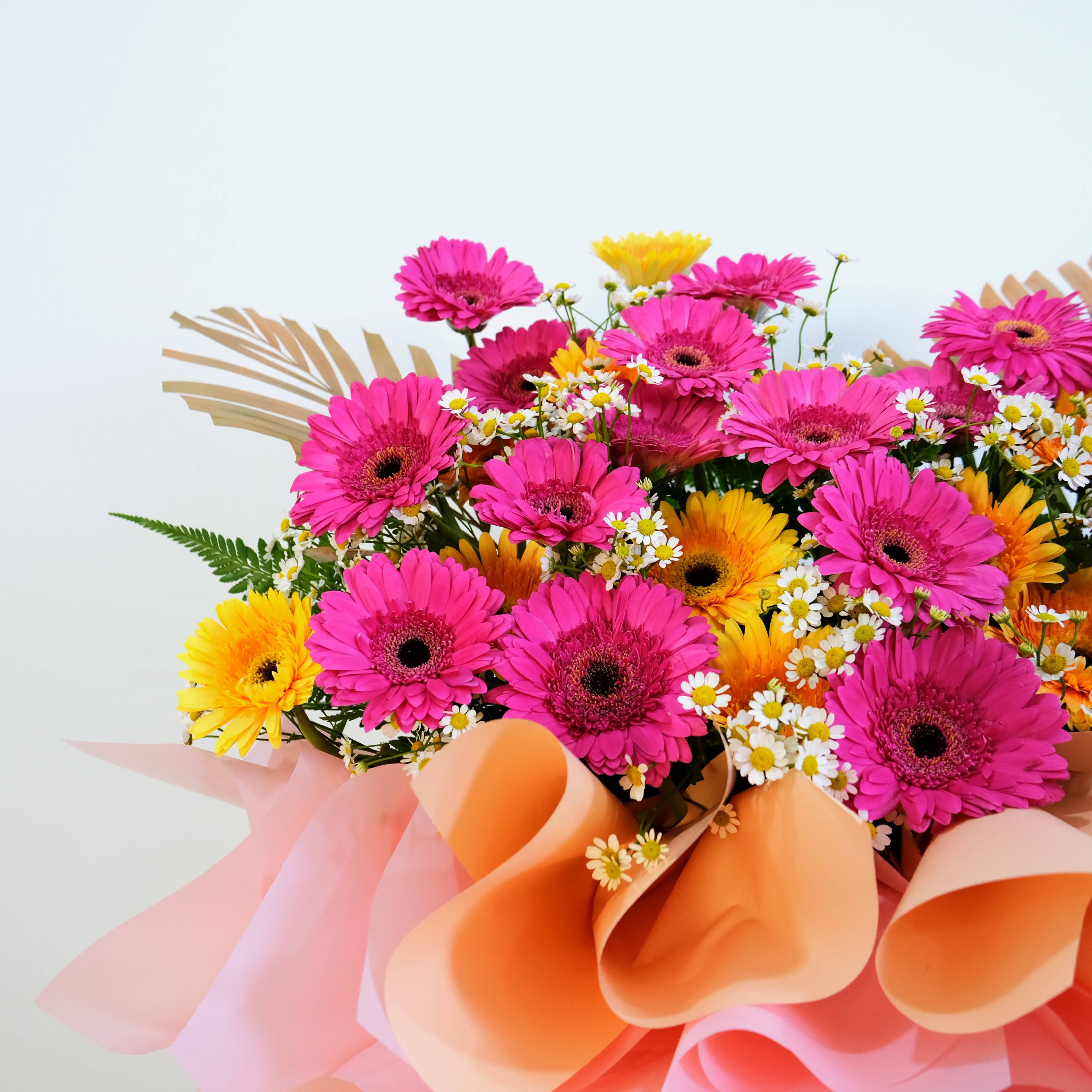 grand opening flower stand of pink and yellow flowers with decorative ribbons on a light background
