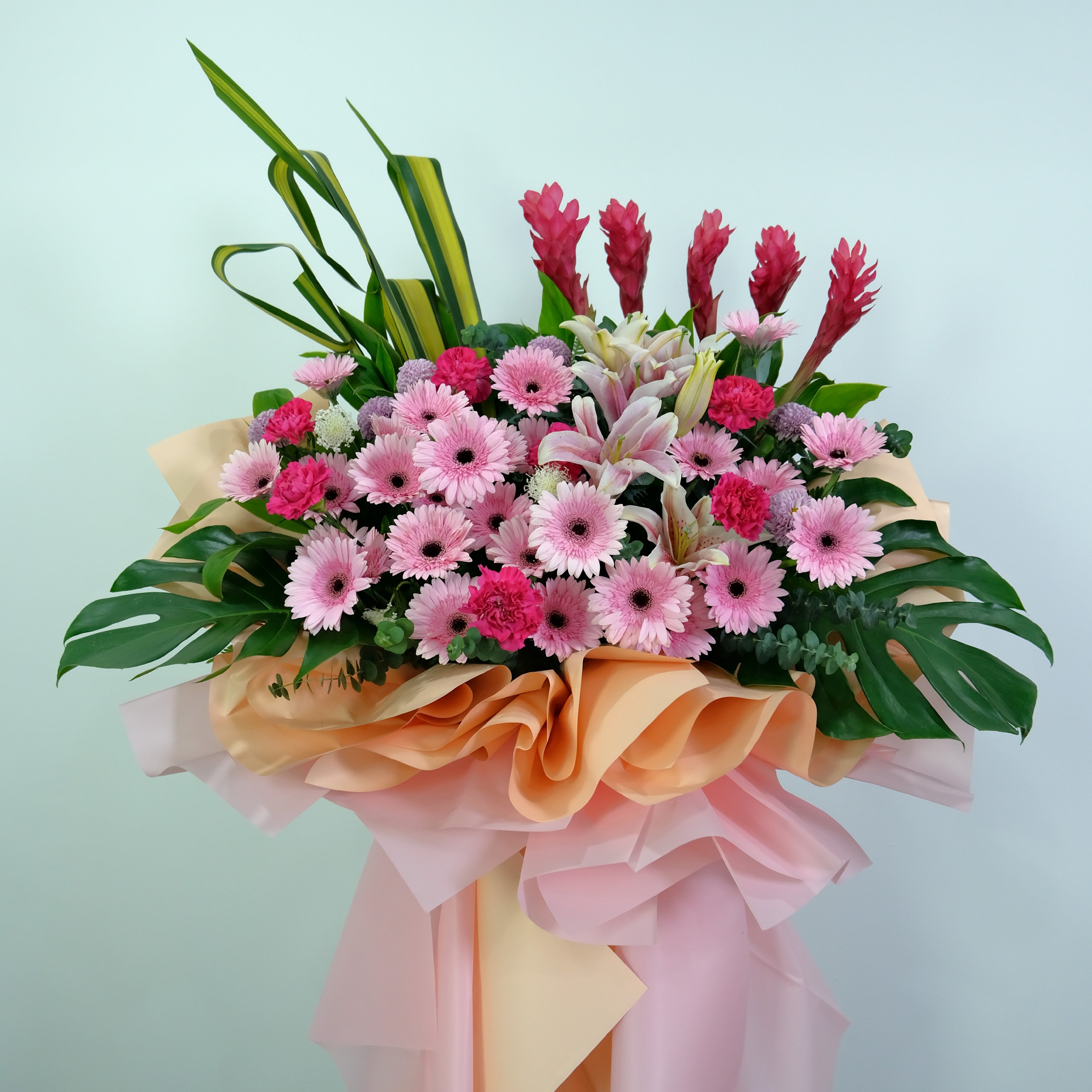 Bouquet of flowers with pink and green colors on a light blue background