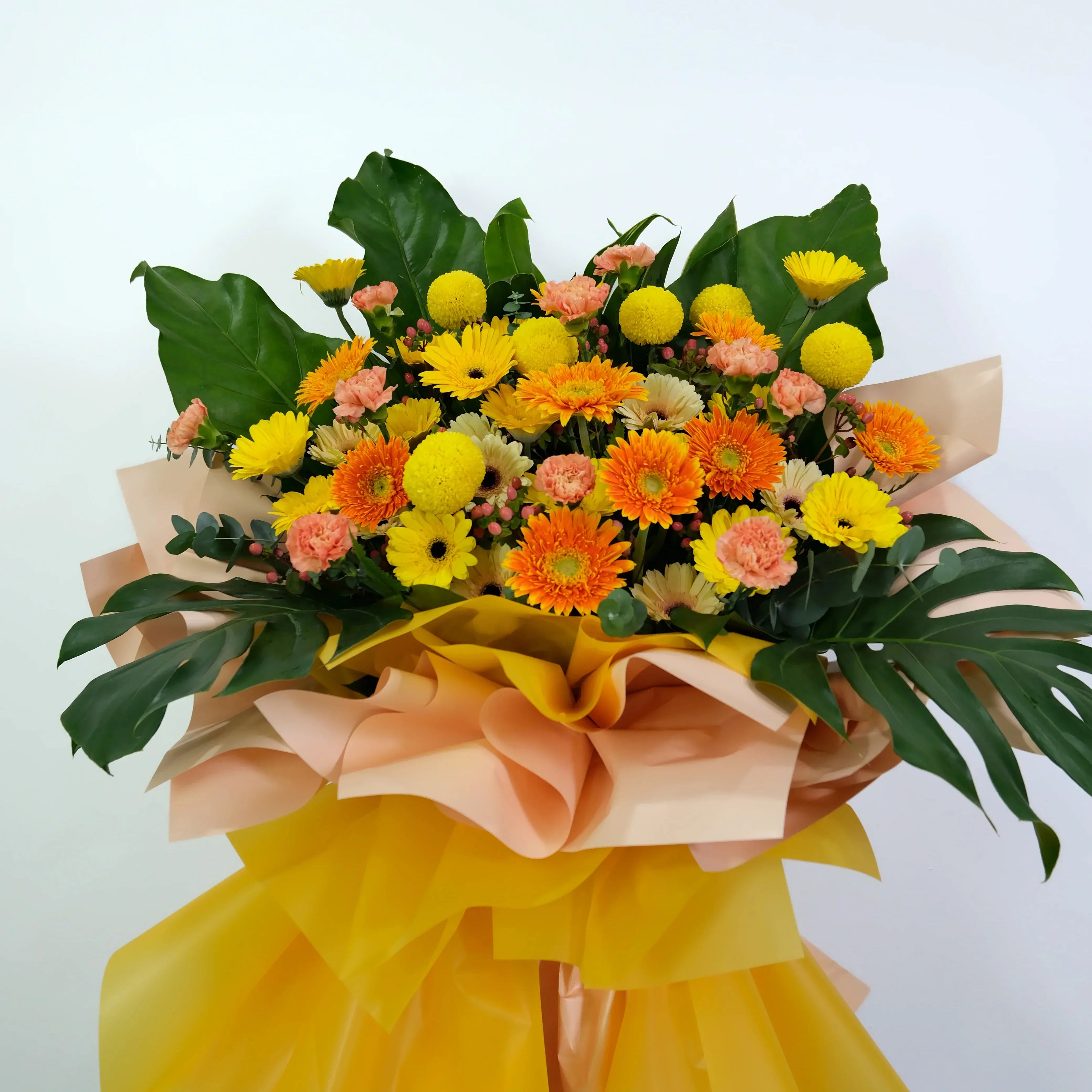 Bouquet of flowers with yellow and green leaves on a light background