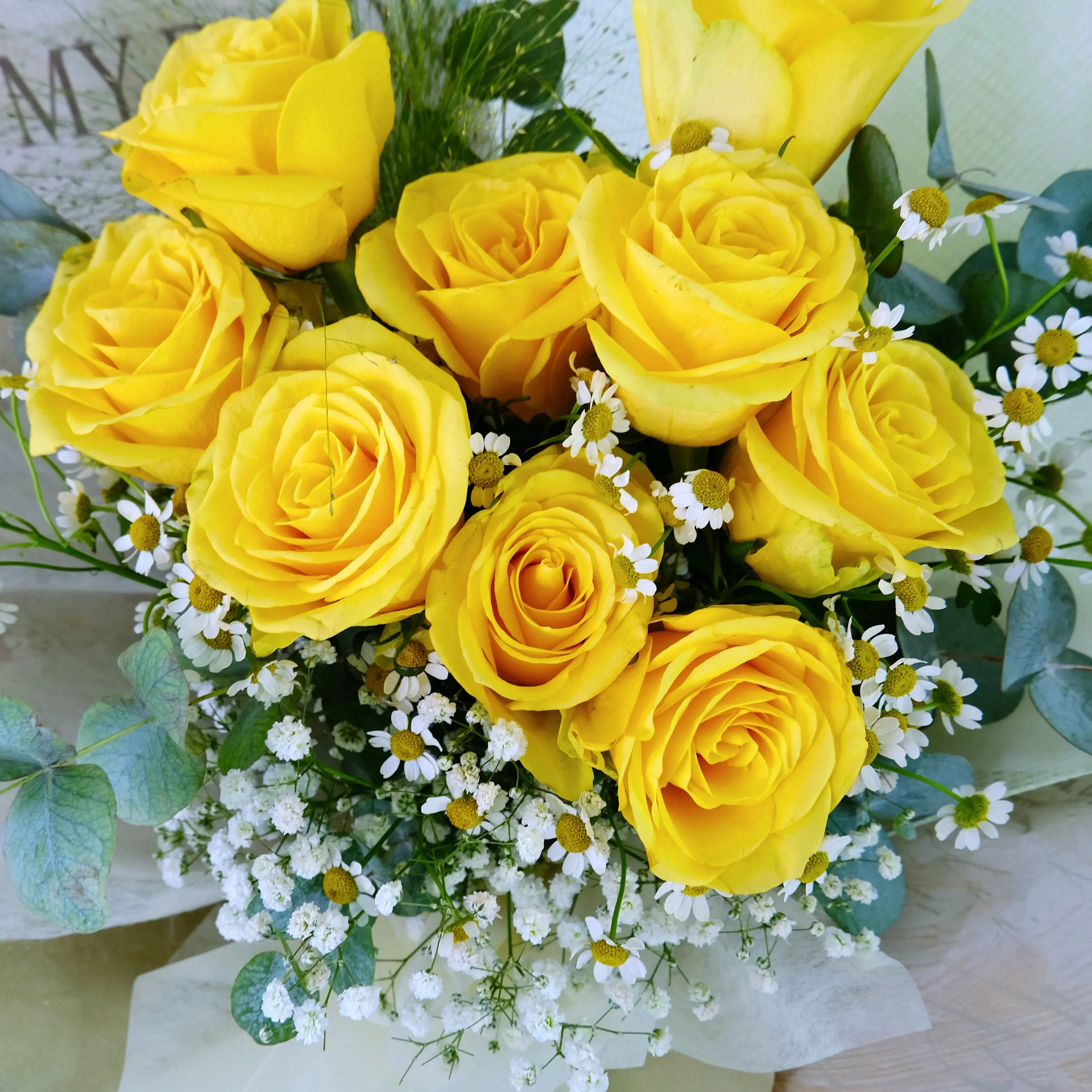 Bouquet of fresh yellow roses with white daisies and green eucalyptus leaves