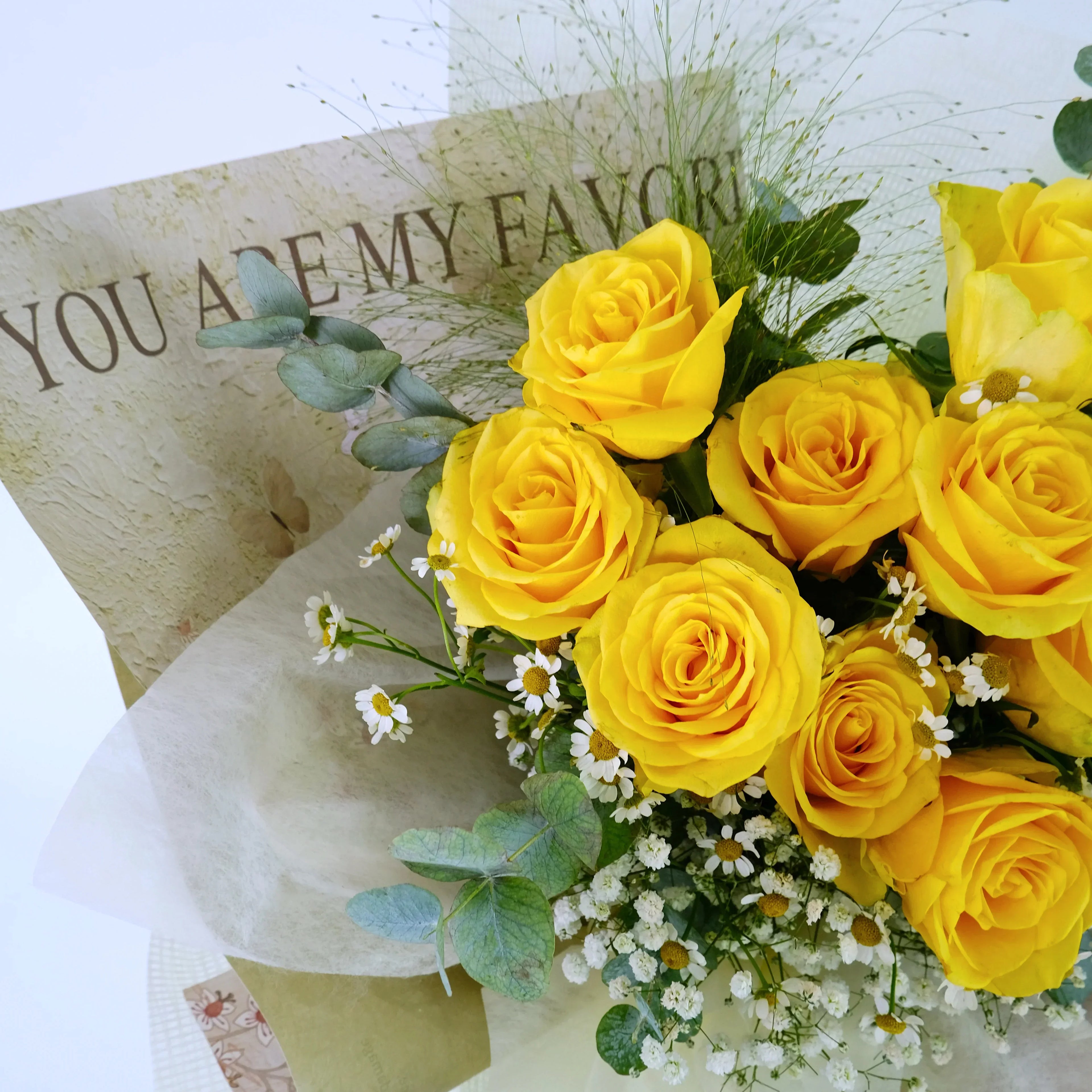 Bouquet of yellow roses, white daisies, greenery with a card saying 'YOU ARE MY FAVOR'