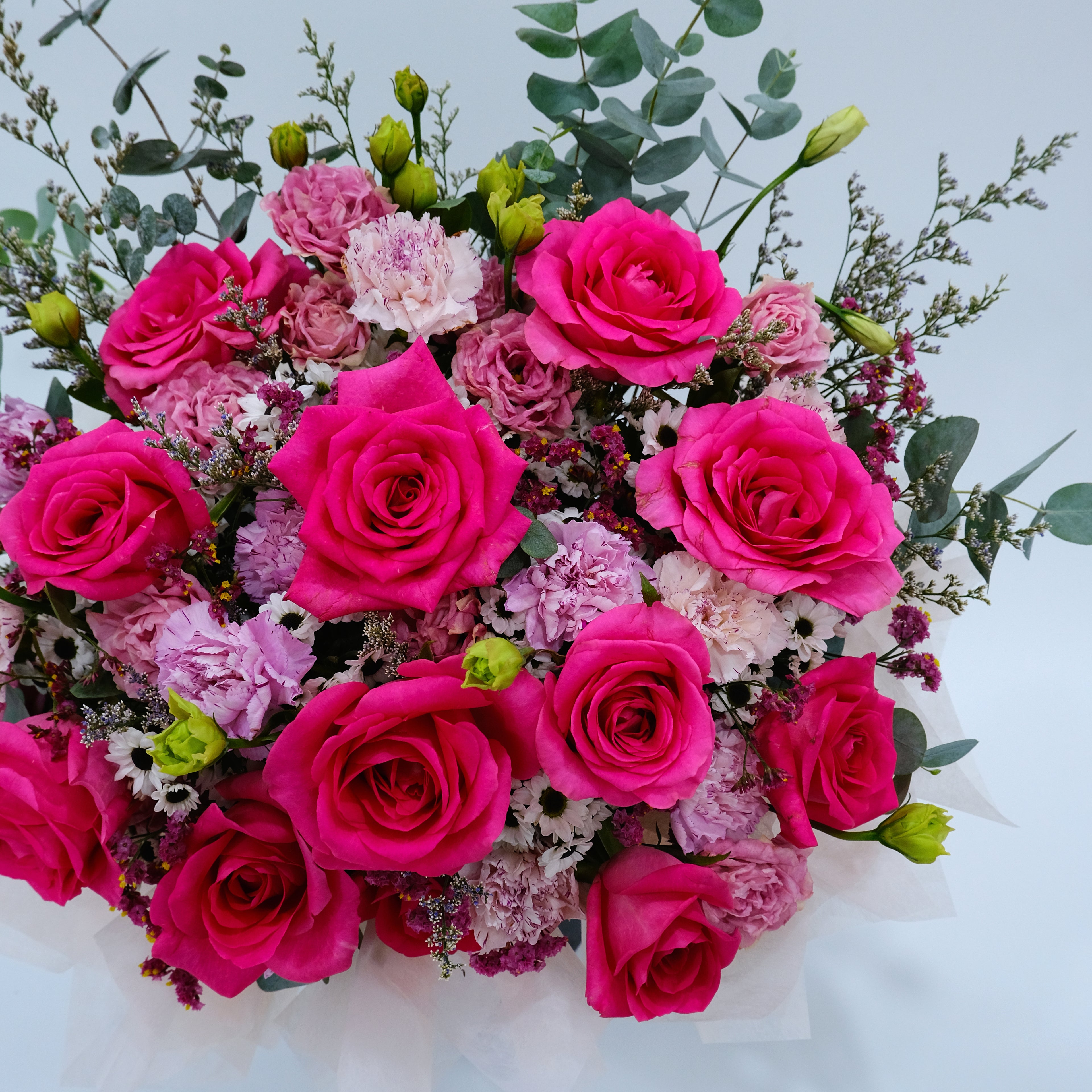 Bouquet of pink roses and other flowers on a light background