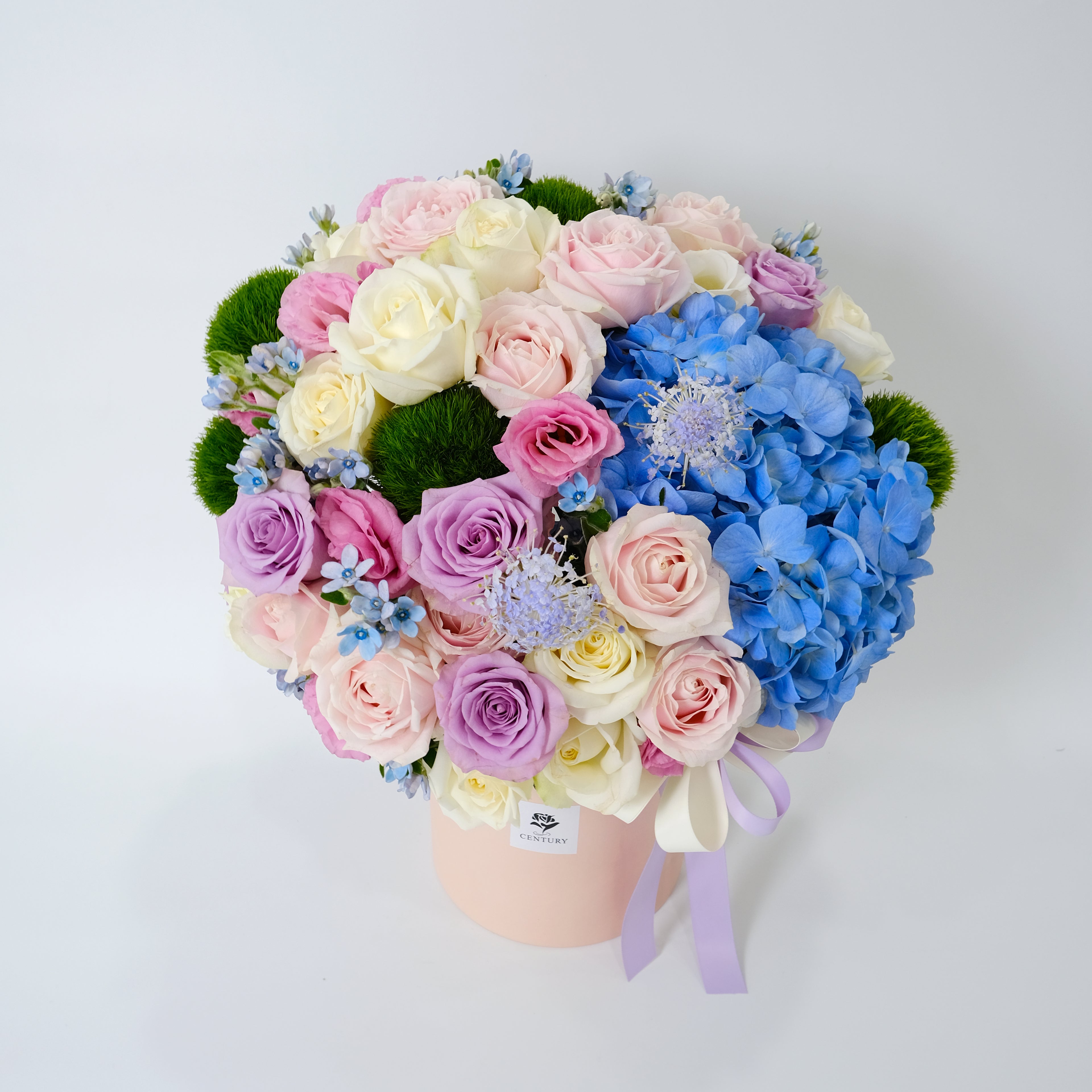 Bouquet of flowers with pink, white, and blue colors in a pink box on a light gray background