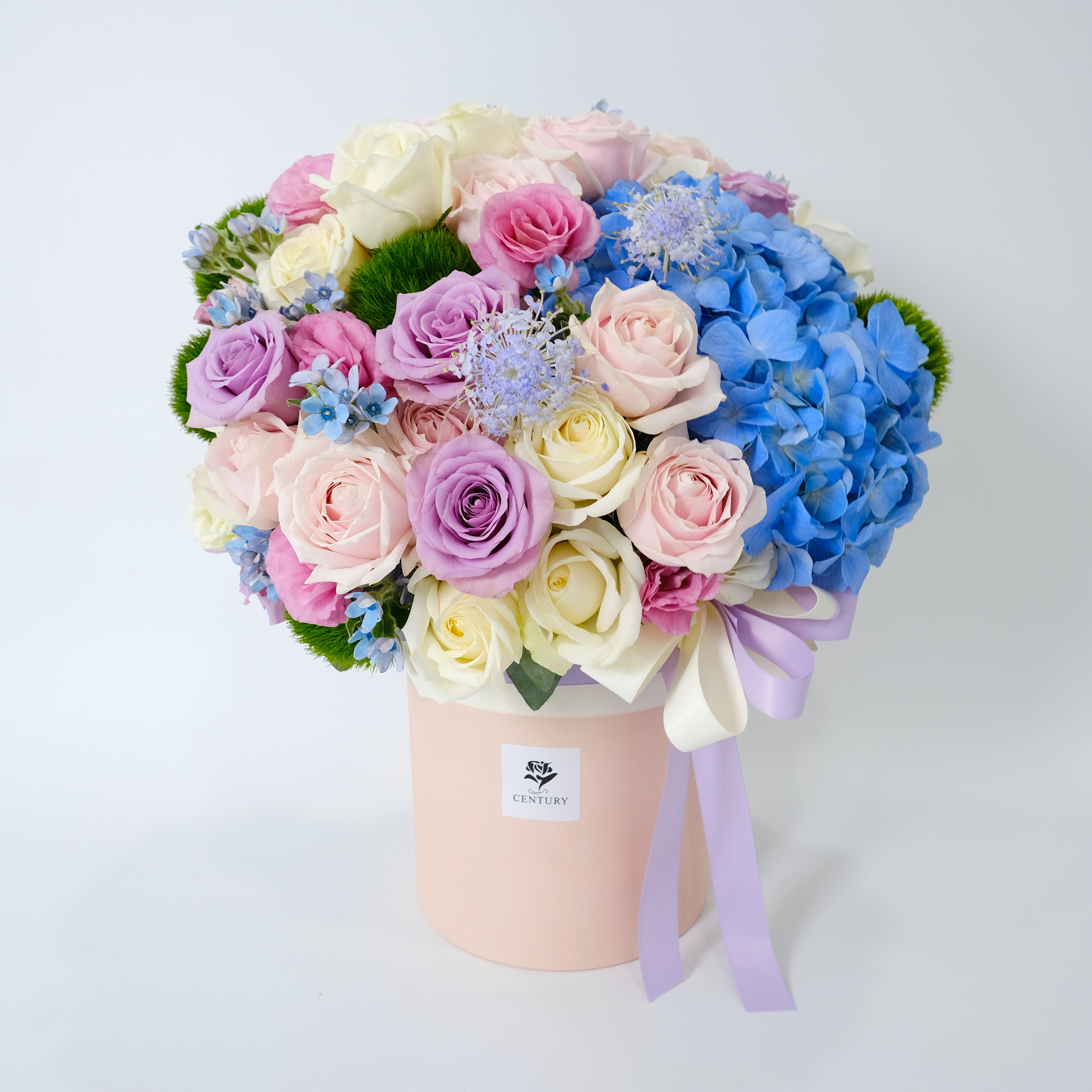 Colorful bouquet of flowers in a box with a visible brand label on a light background
