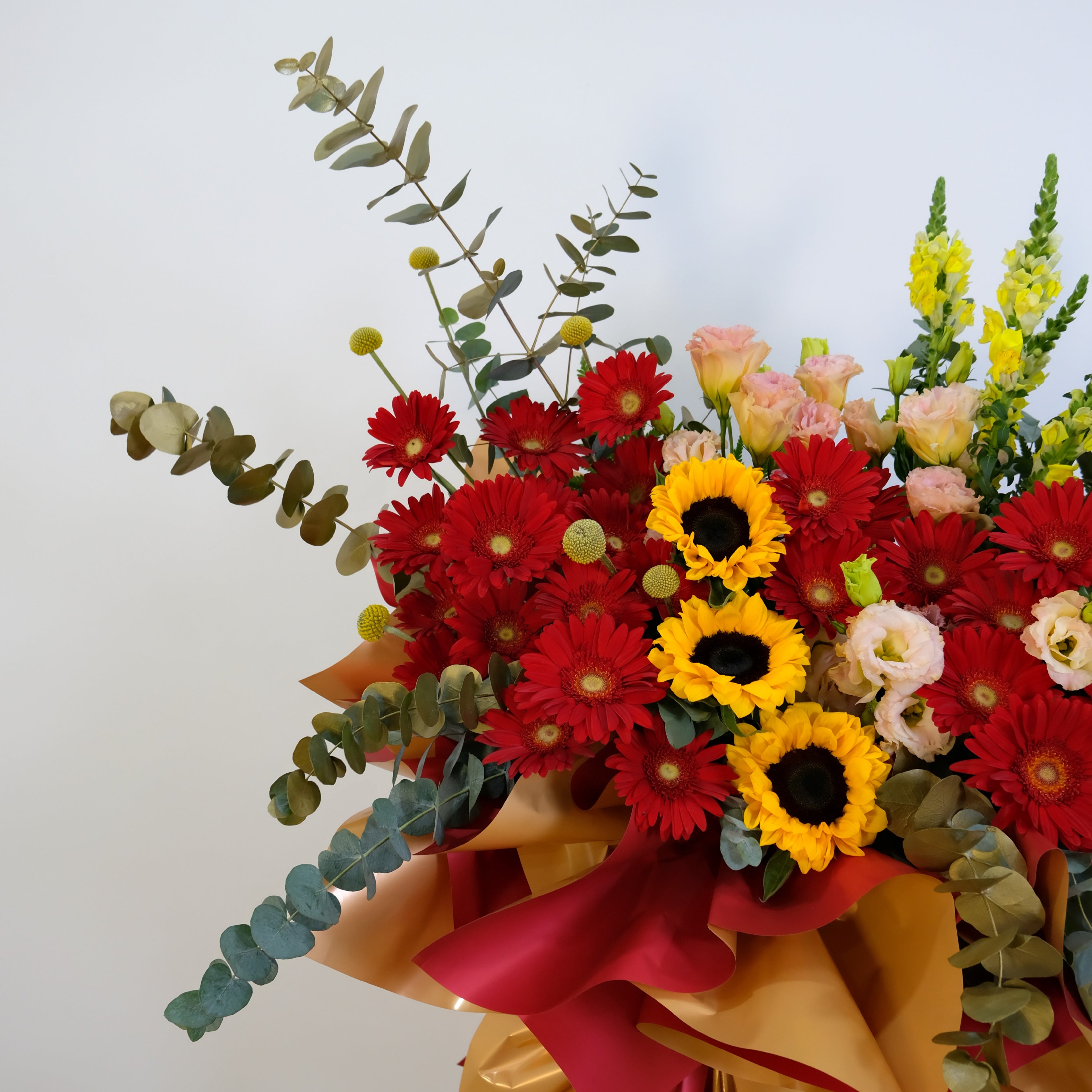 Bouquet of colorful flowers with red, yellow, and pink flowers on a light background