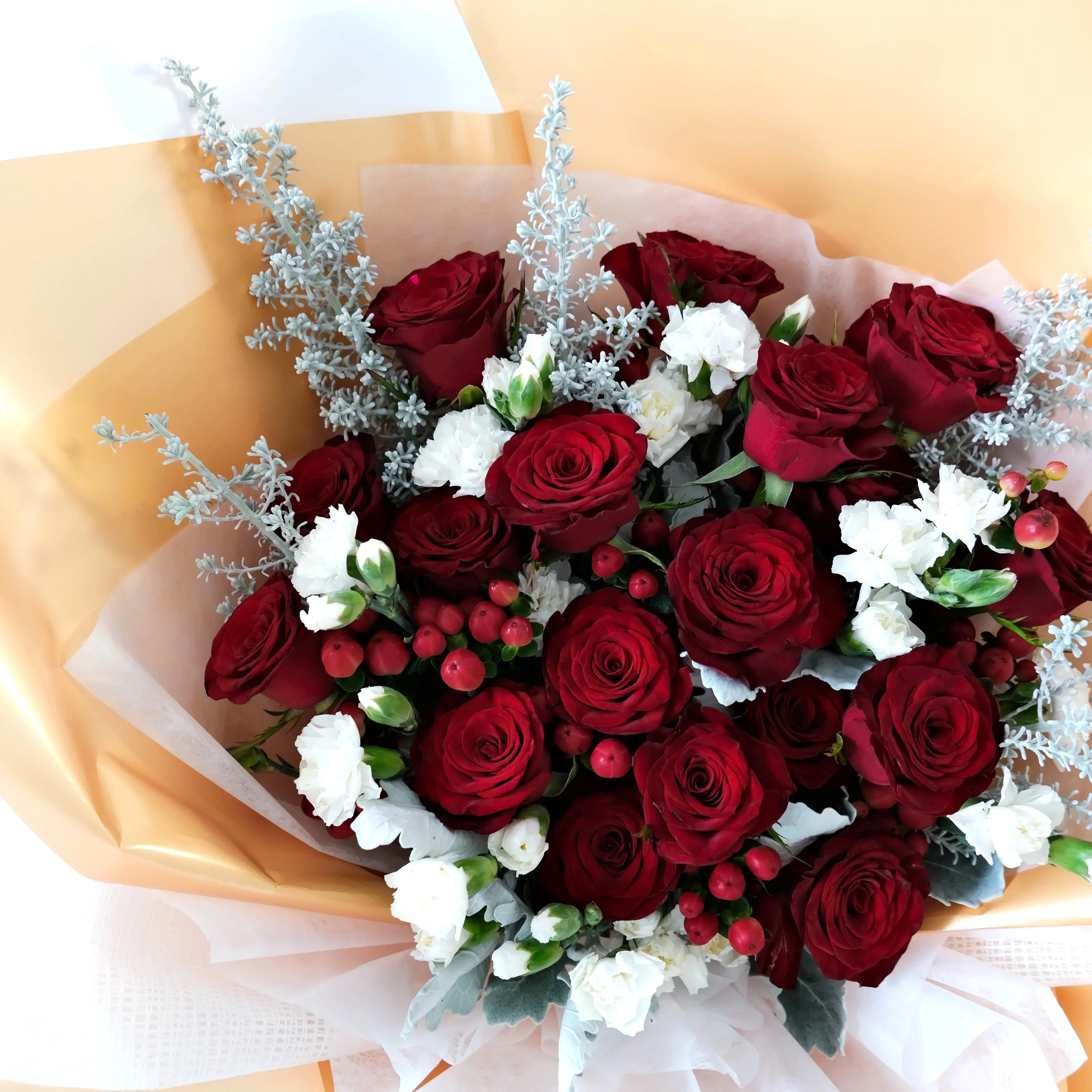 Bouquet of red roses and white flowers with gold wrap