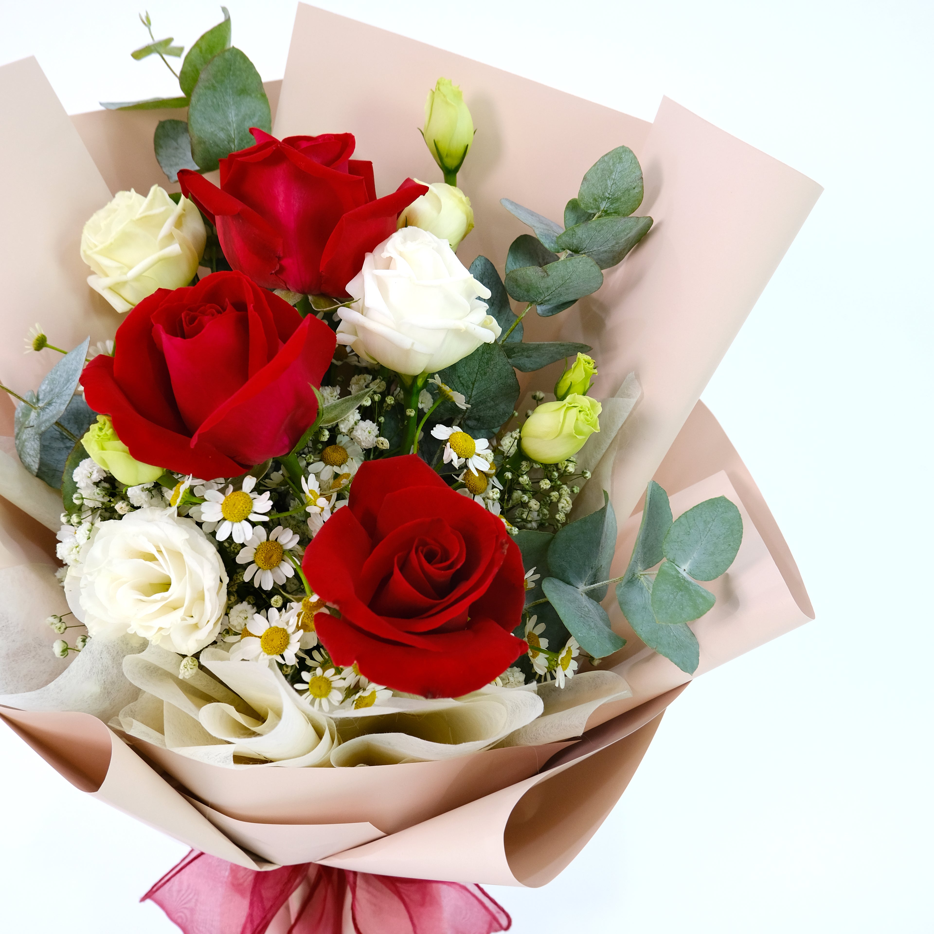 Bouquet of red and white roses with greenery on a light background