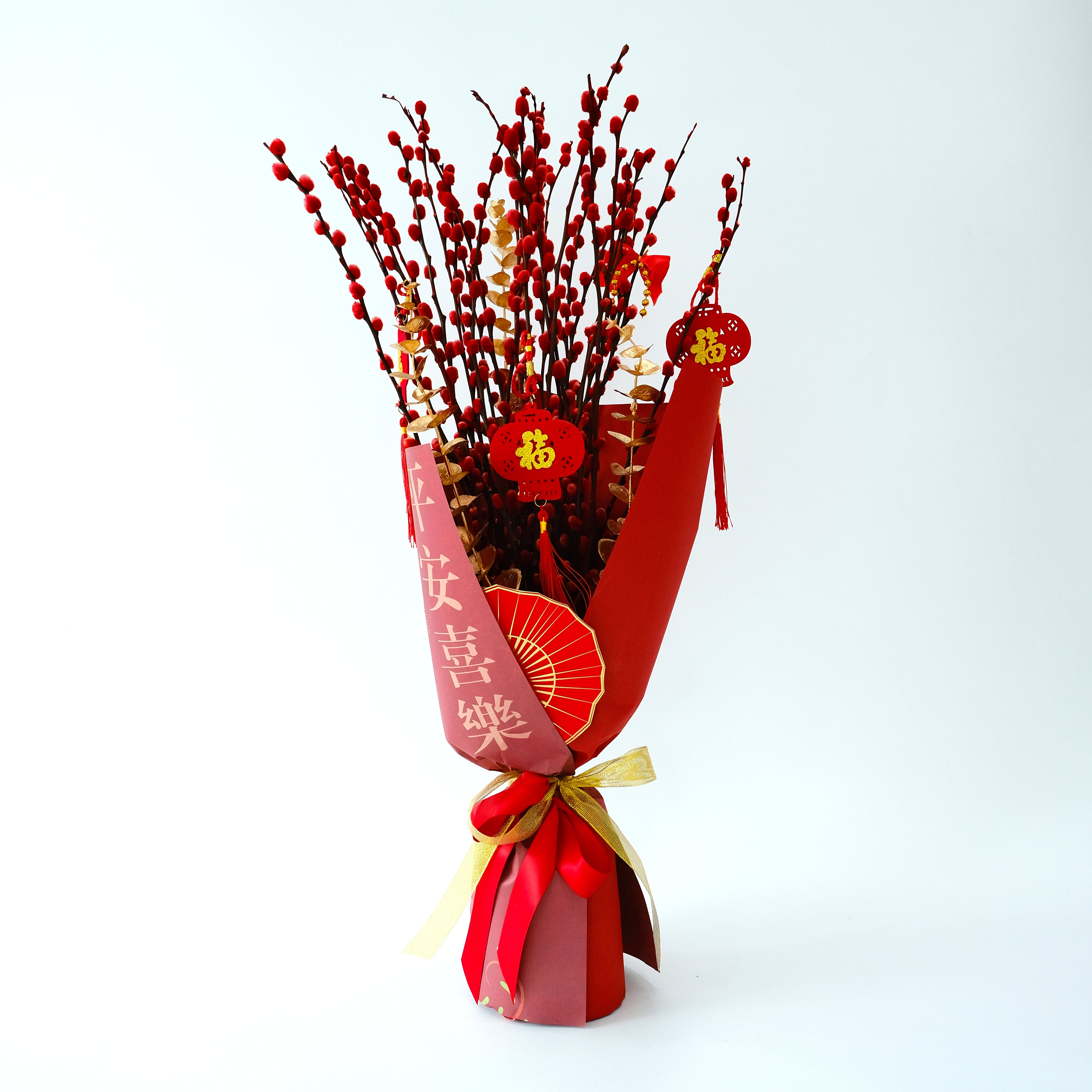 Bouquet of red and gold branches with decorative ribbons and Chinese characters on a white background