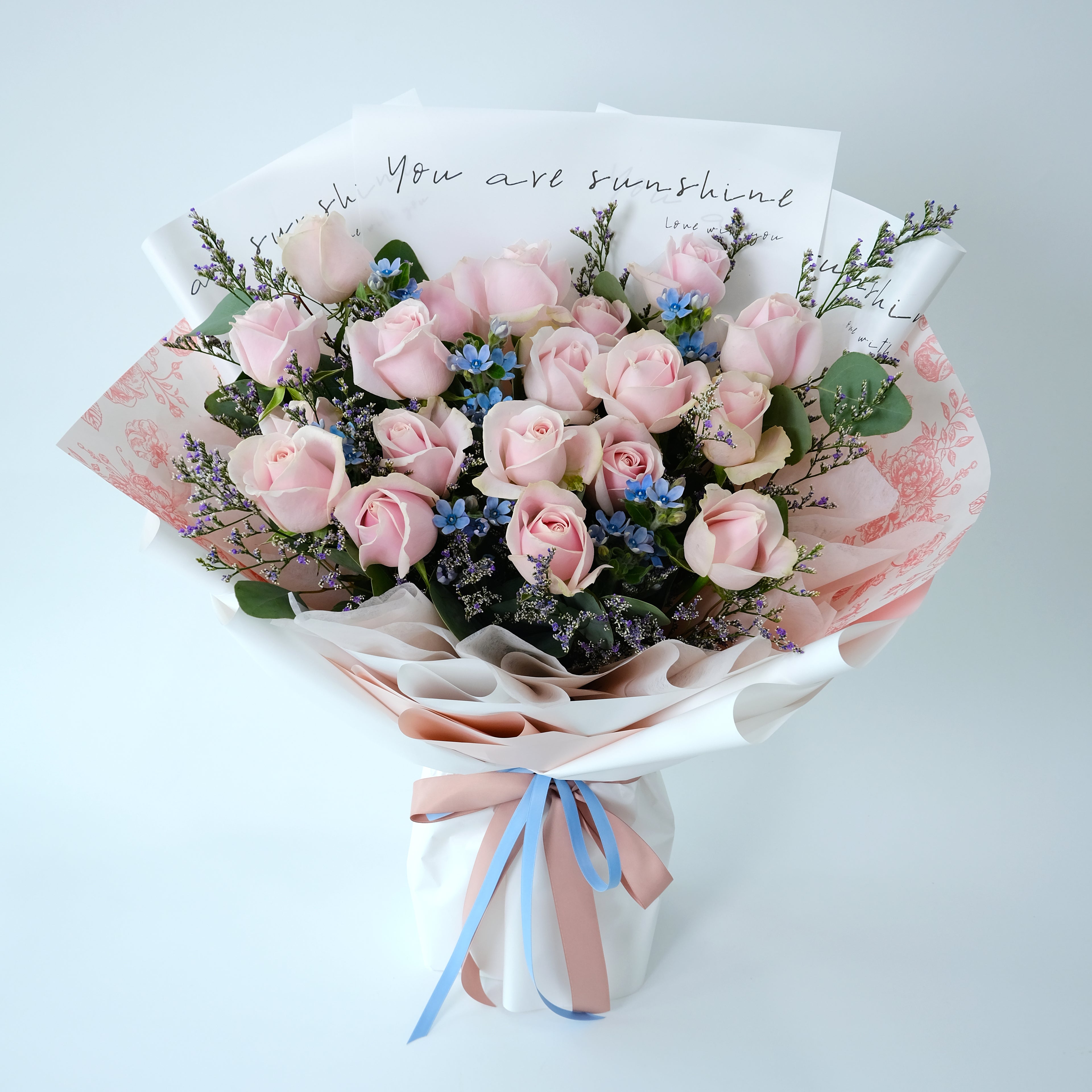 Bouquet of pink roses with a card on a light gray background