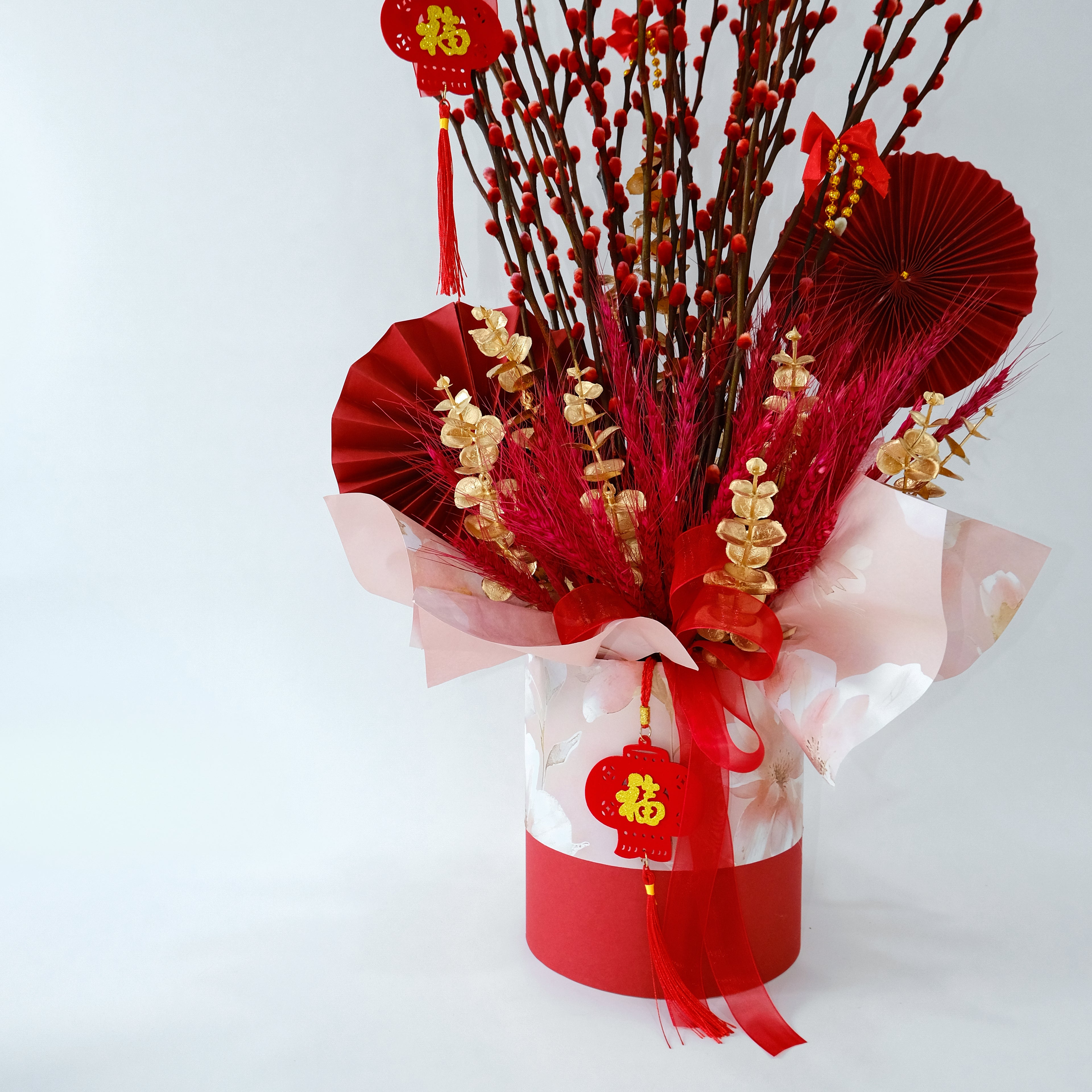 Decorative arrangement with red and gold elements on a white background