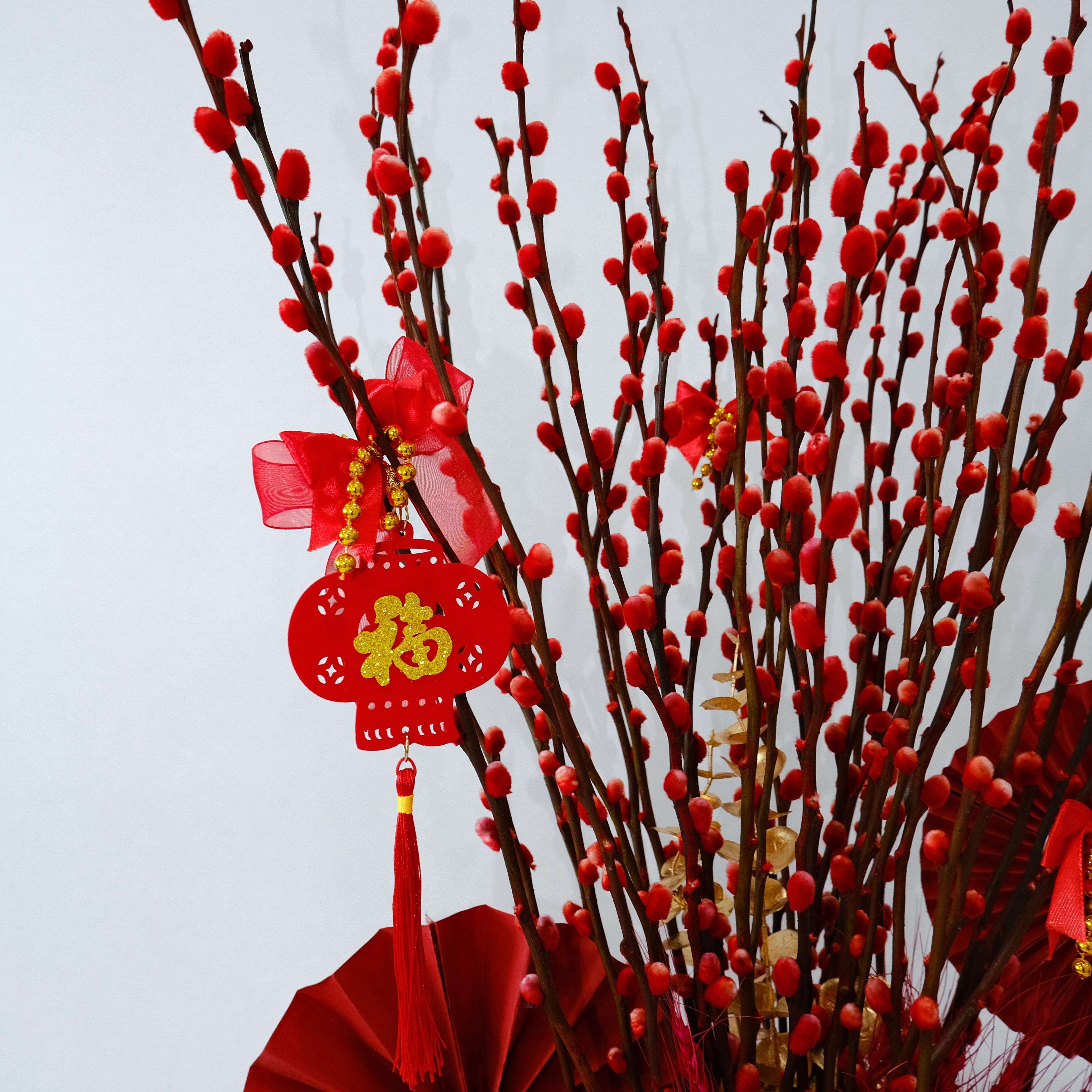 Red decorative elements with tassels and a lantern on a light gray background