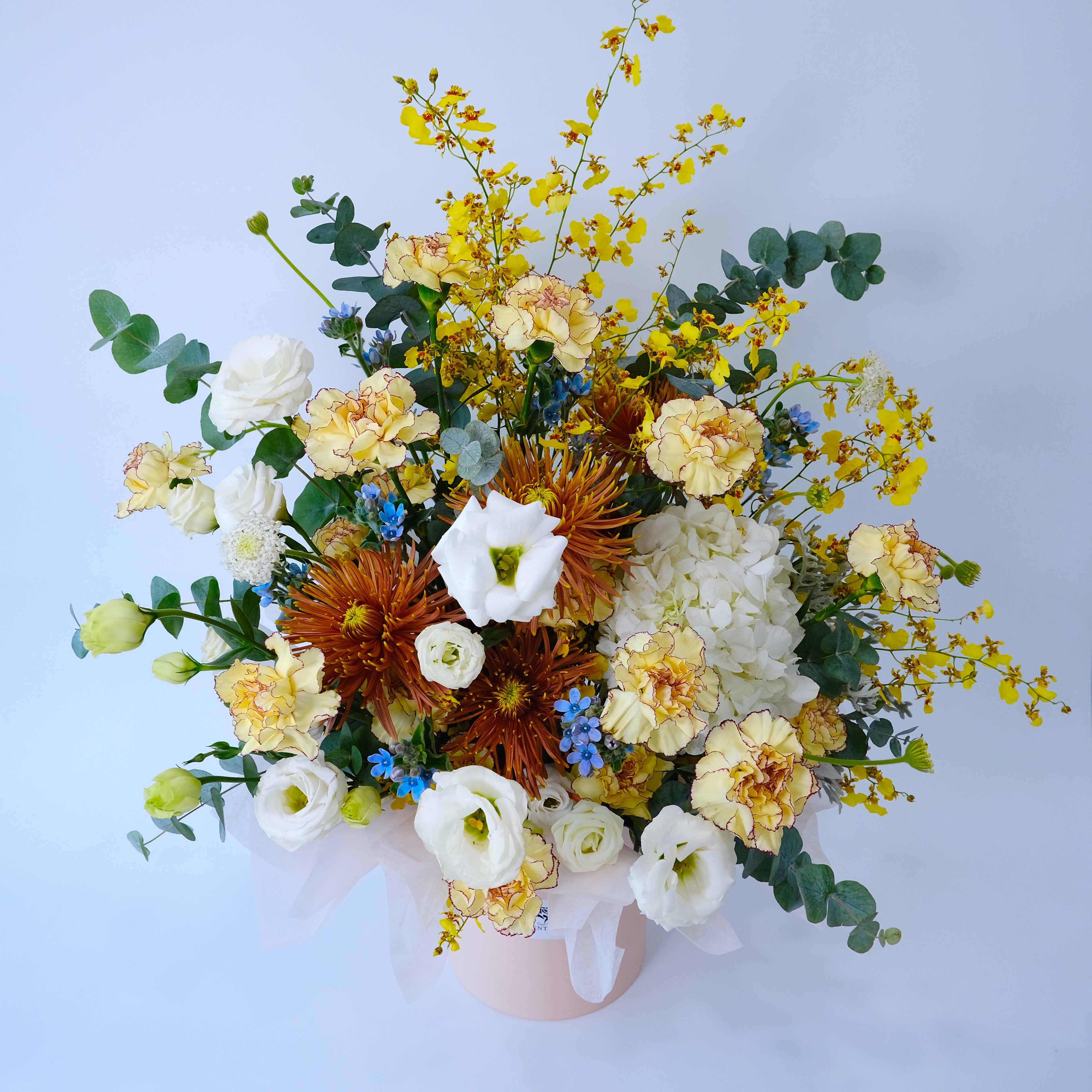 Bouquet of flowers in a pink vase on a light blue background