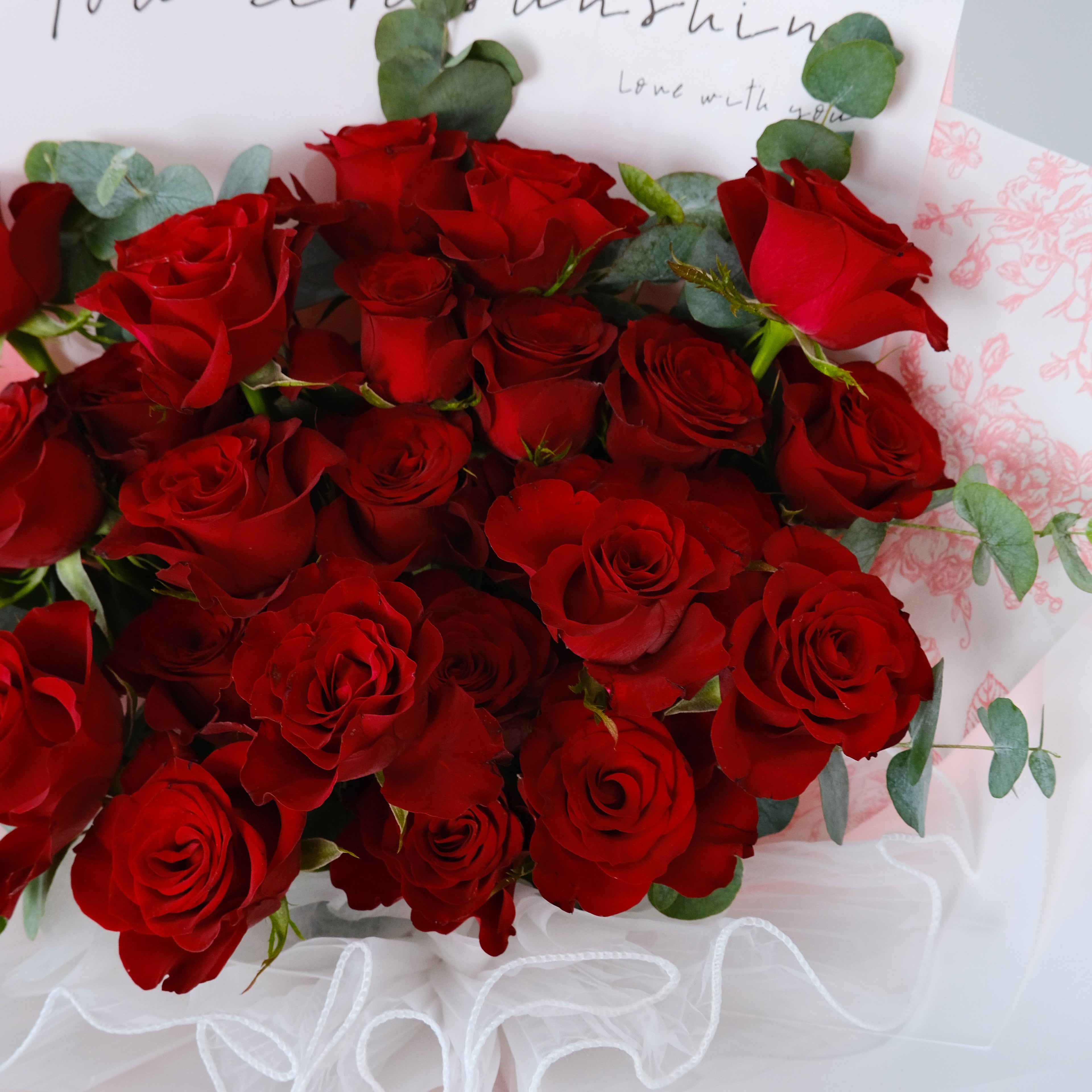 Bouquet of red roses with green leaves on a white background