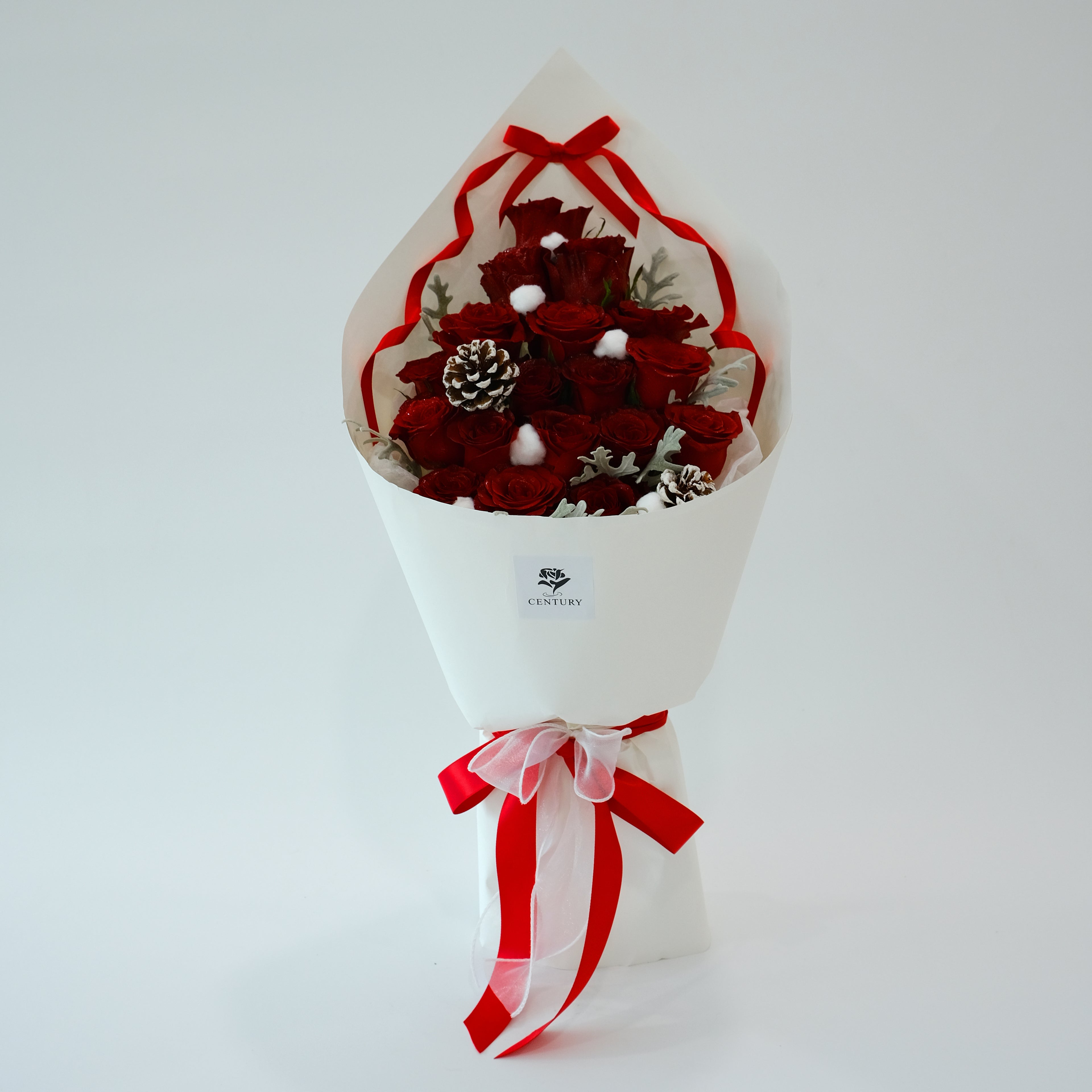 Bouquet of red flowers with a white wrap and red ribbon on a light gray background