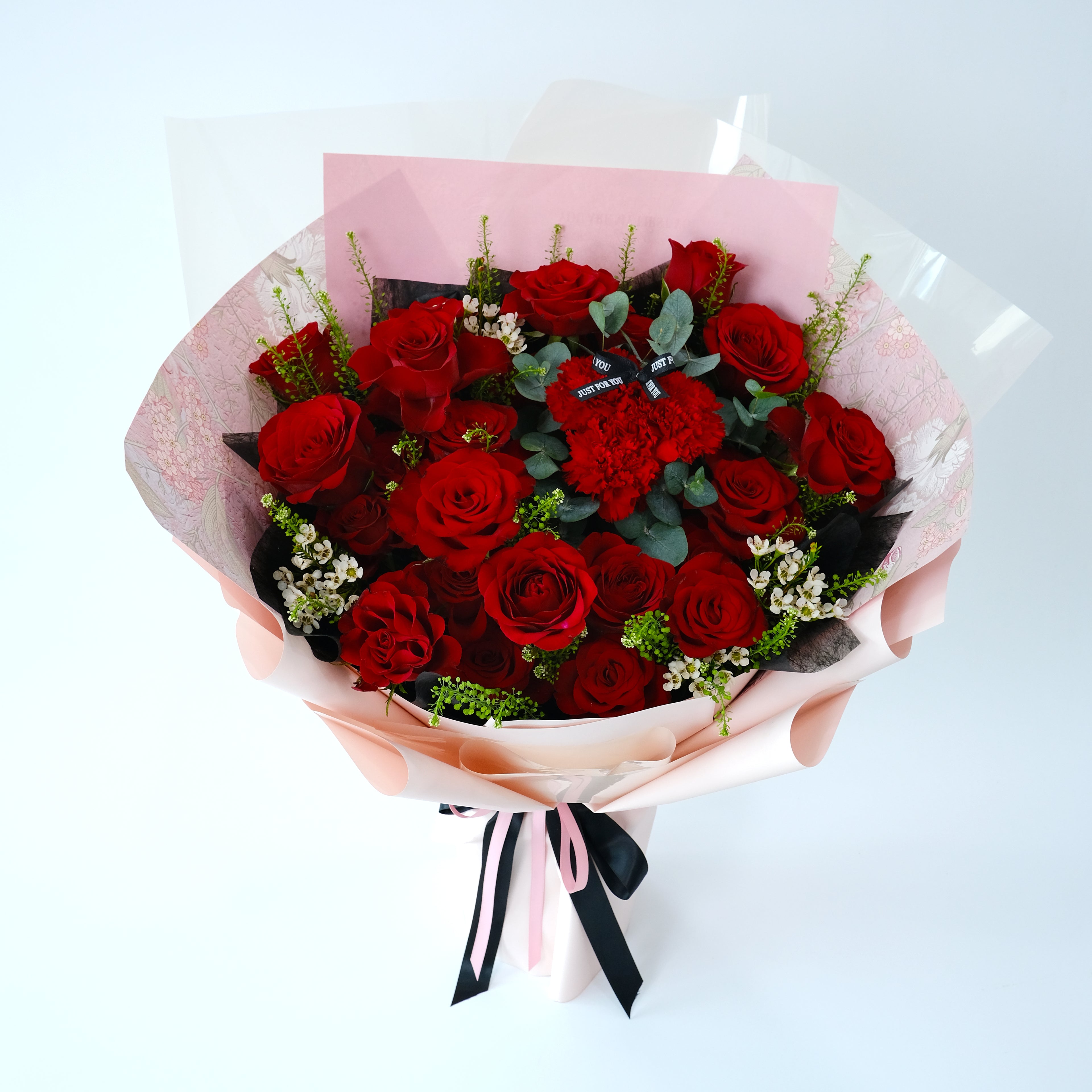 Bouquet of red roses with a black and white ribbon on a light background