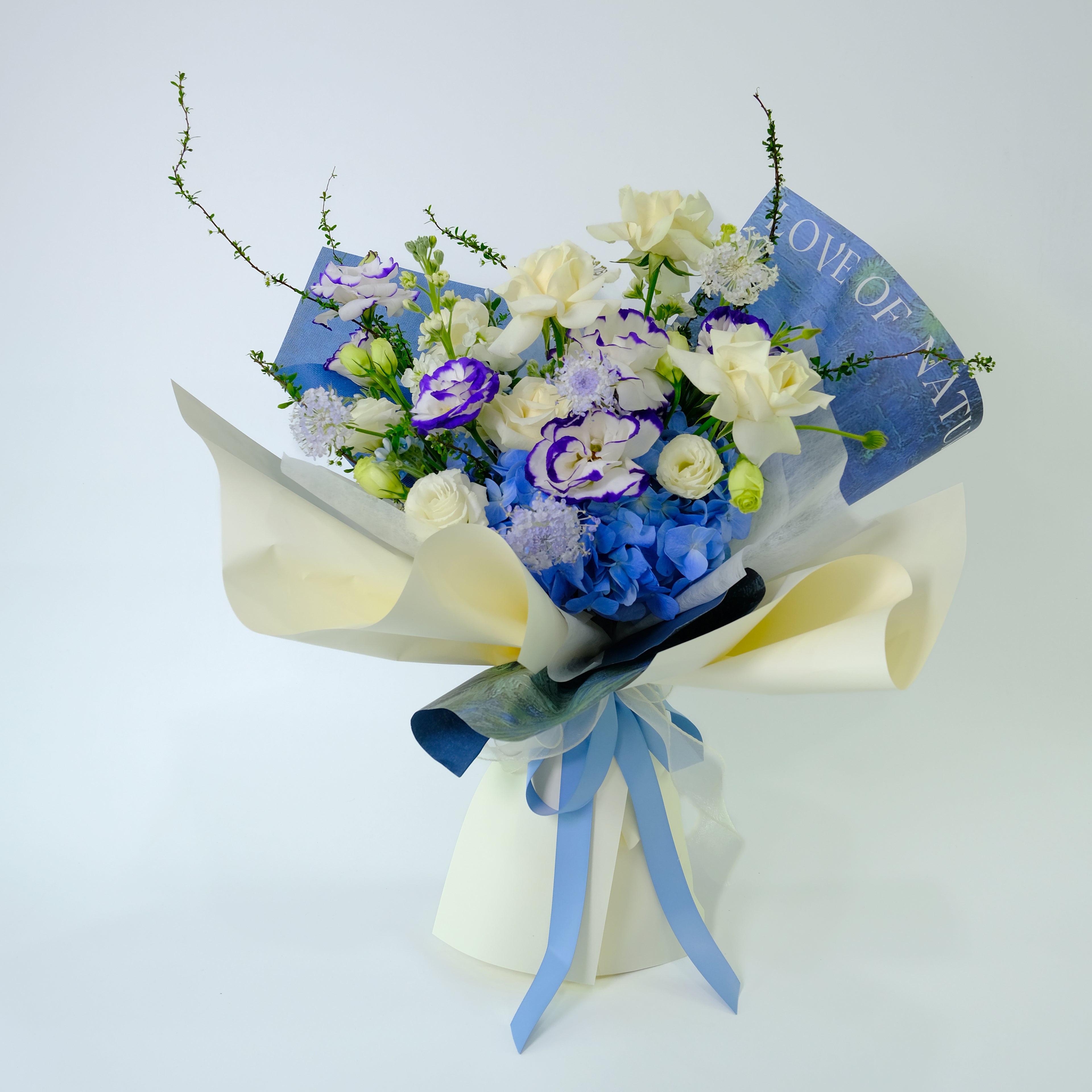 Premium Willow Bouquet featuring royal blue hydrangea, white roses, and blue-tipped lisianthus, wrapped in blue and cream paper for delivery in Kuala Lumpur.